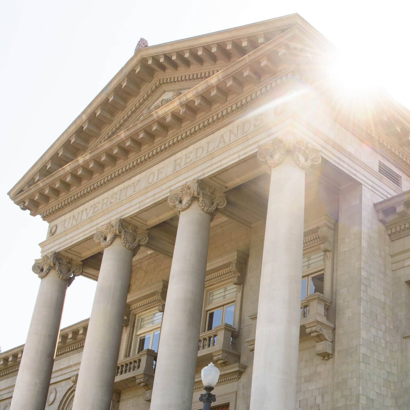 a building with columns and sun shining