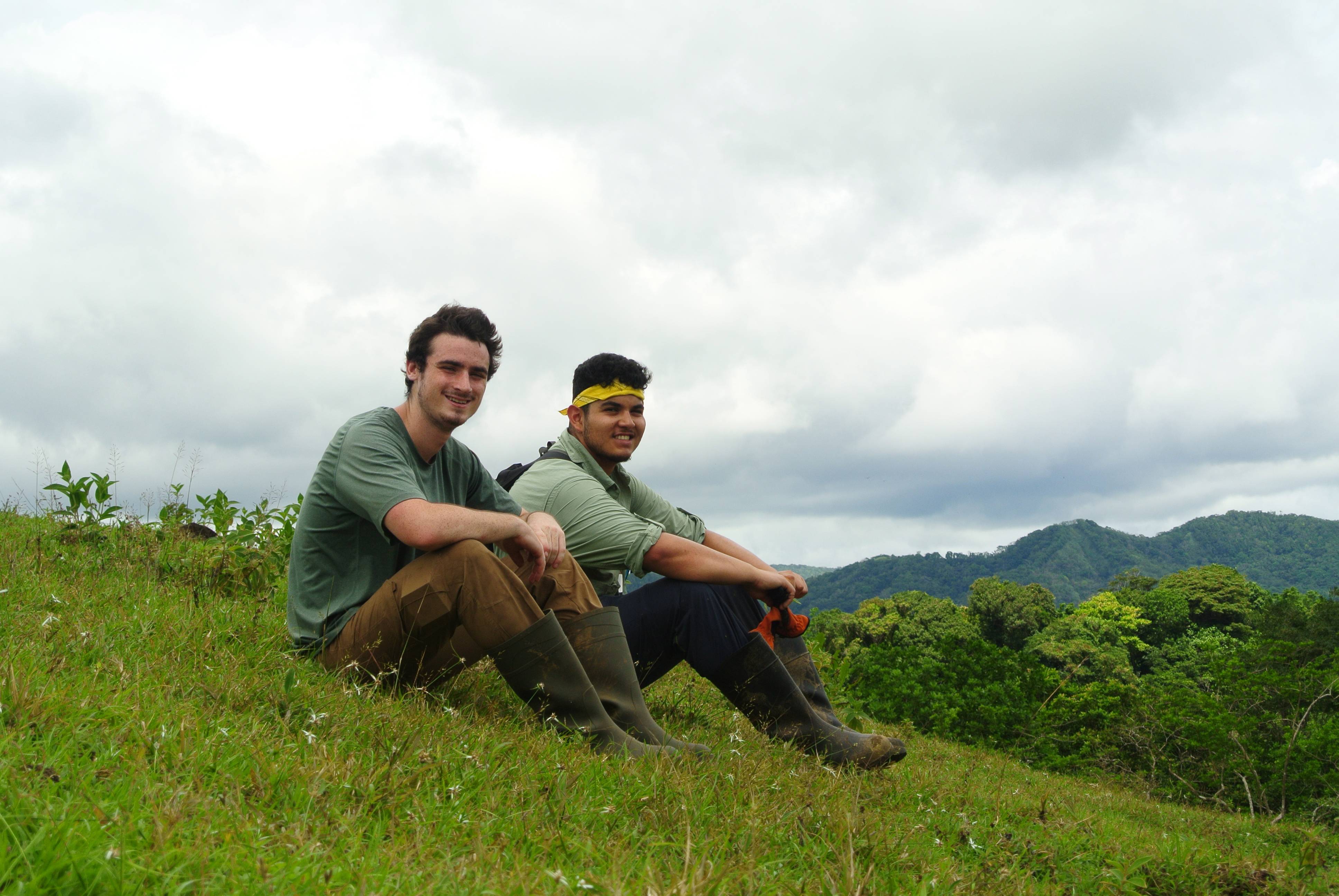 two men sitting on a hill