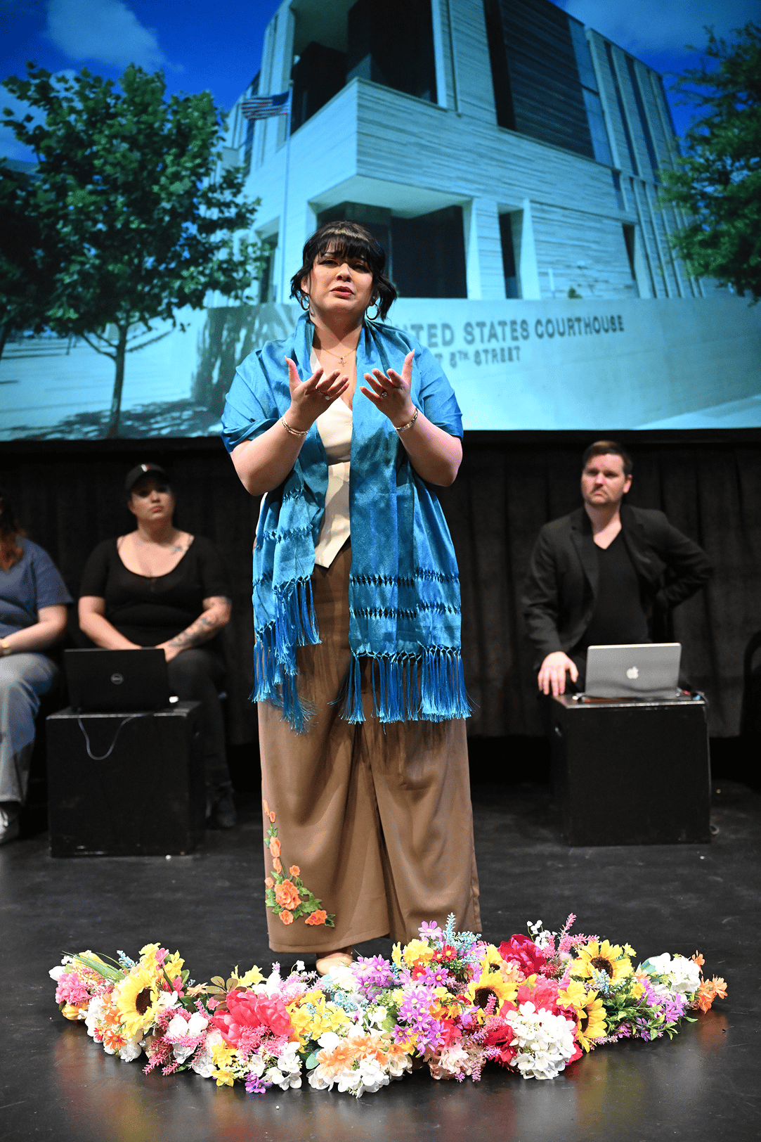 a person standing on a stage with a group of people behind her