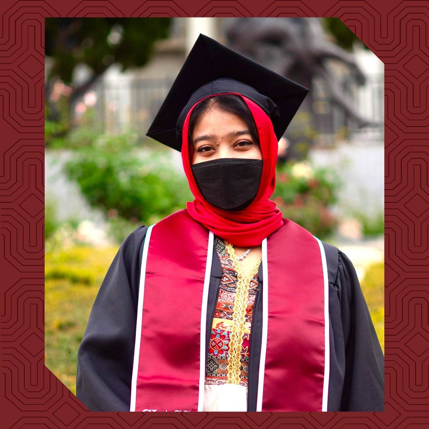 a person wearing a black and red scarf and graduation cap