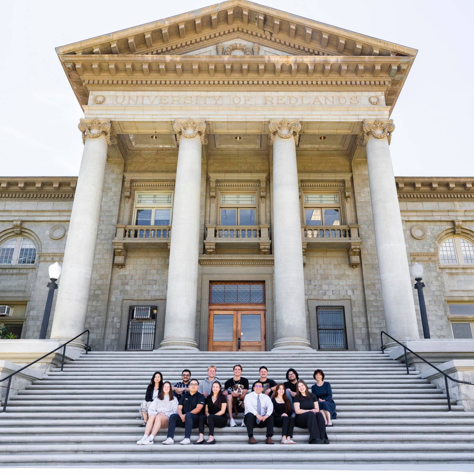 a group of people posing for a photo in front of a building
