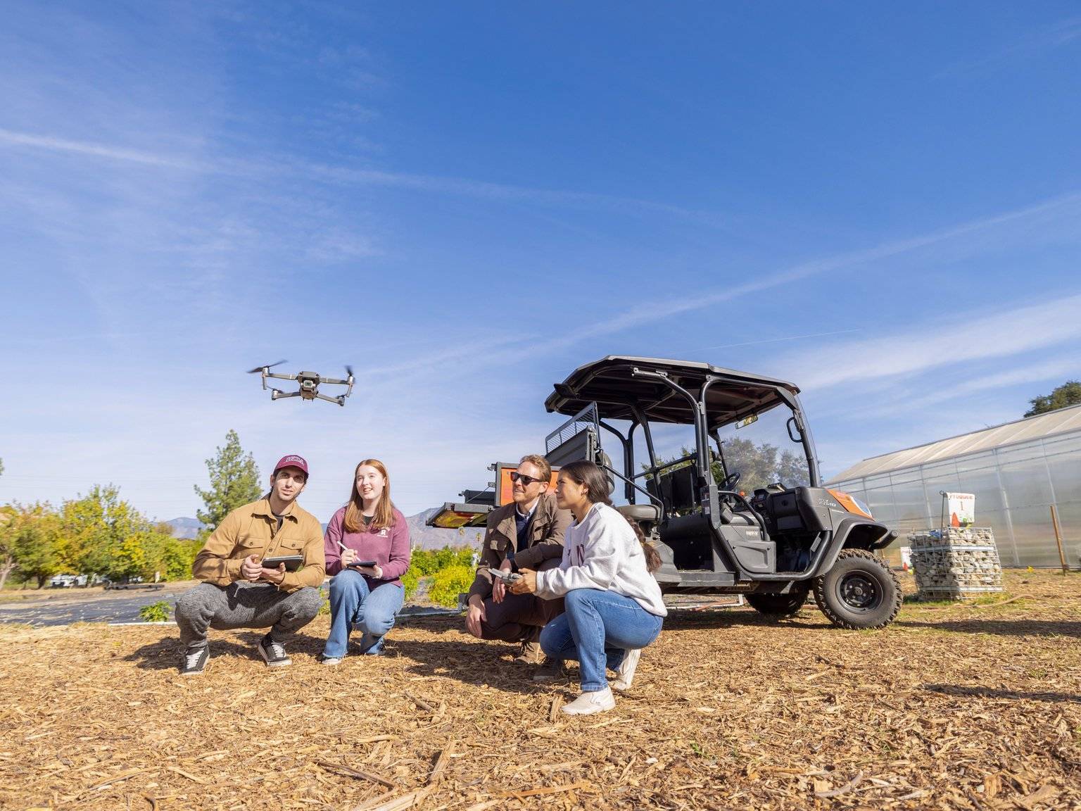 a group of people sitting next to a small vehicle