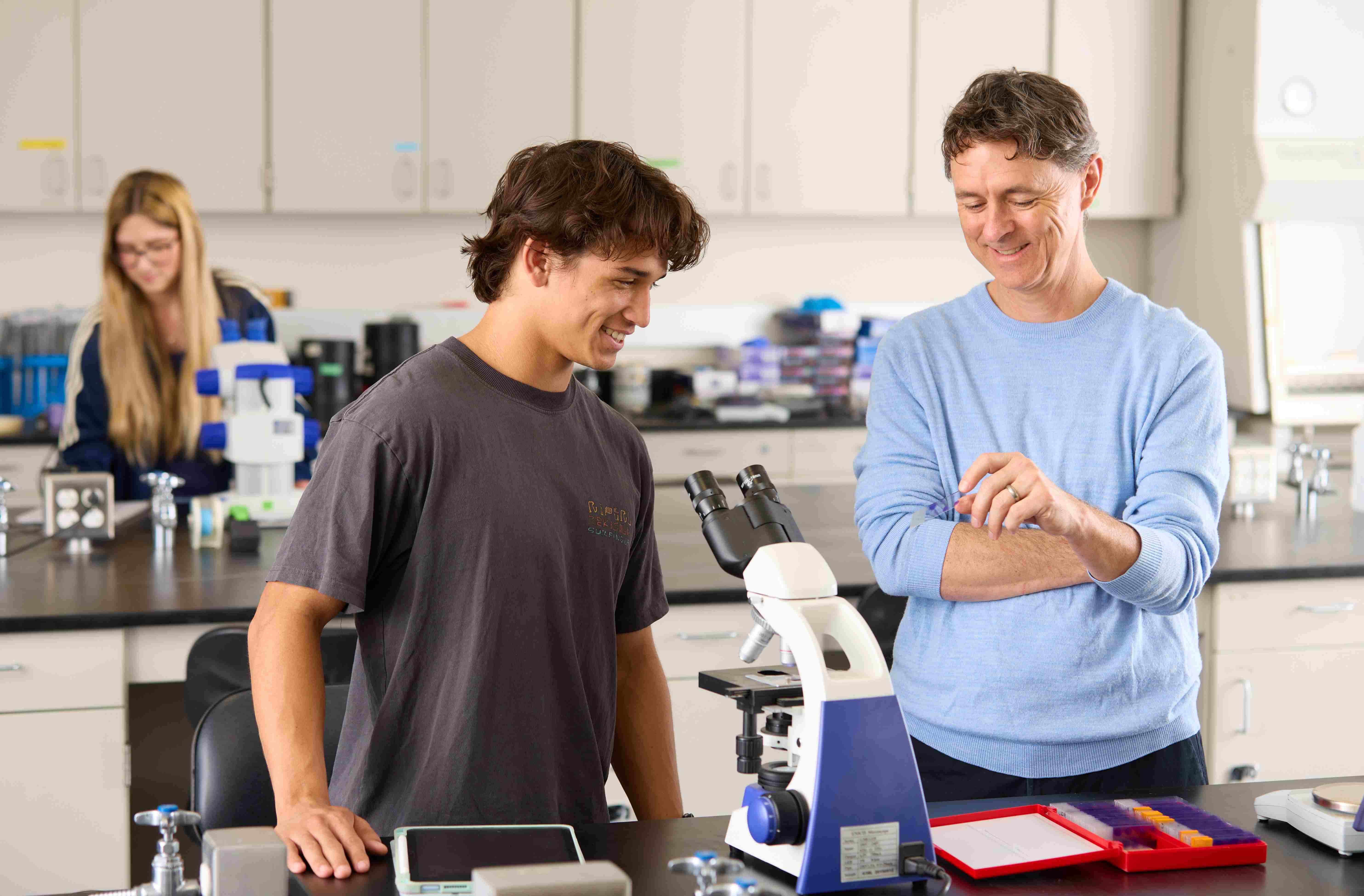 a person looking at a person in a microscope
