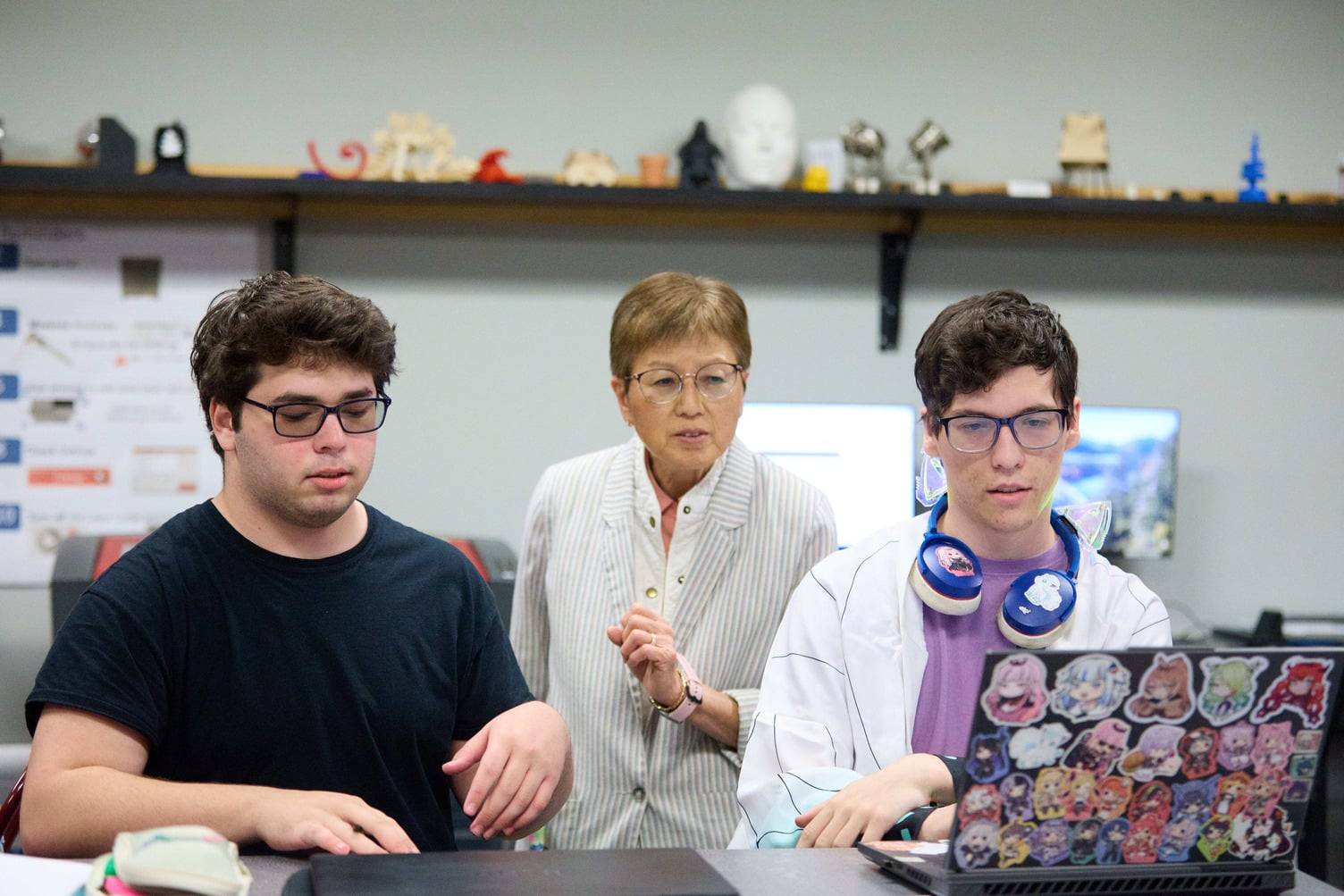 a group of people looking at a laptop