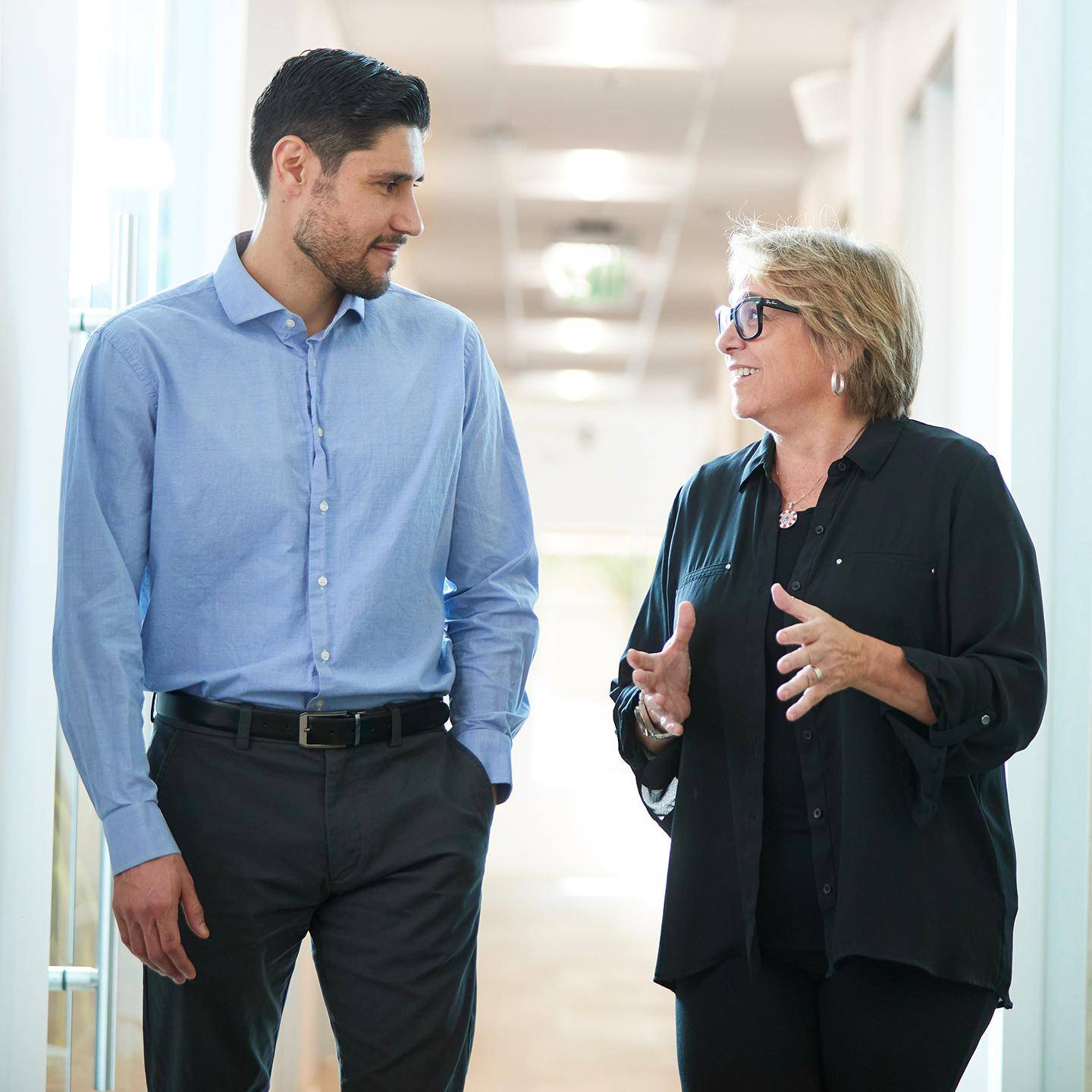 a person and person talking in a hallway