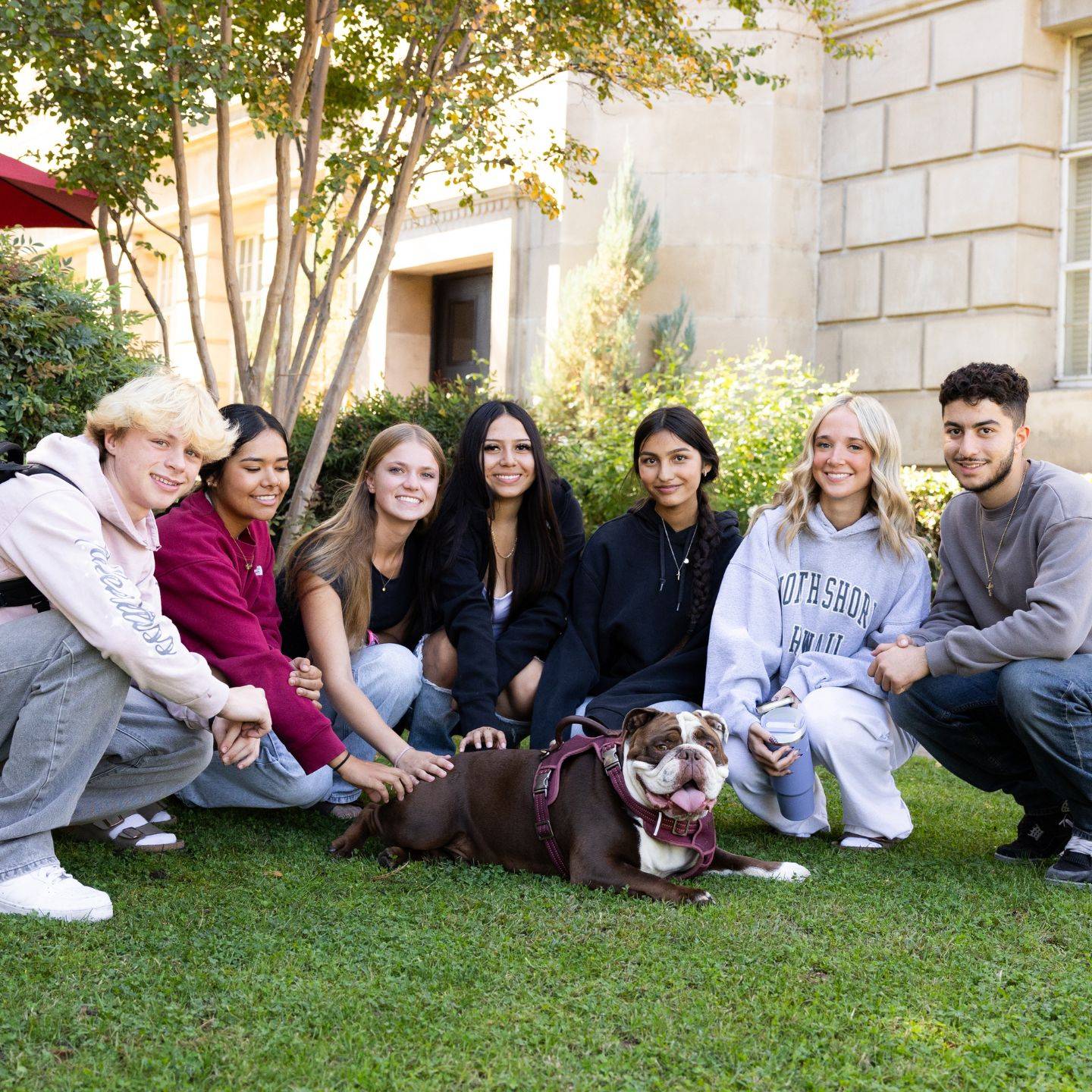 a group of people posing for a picture with a dog