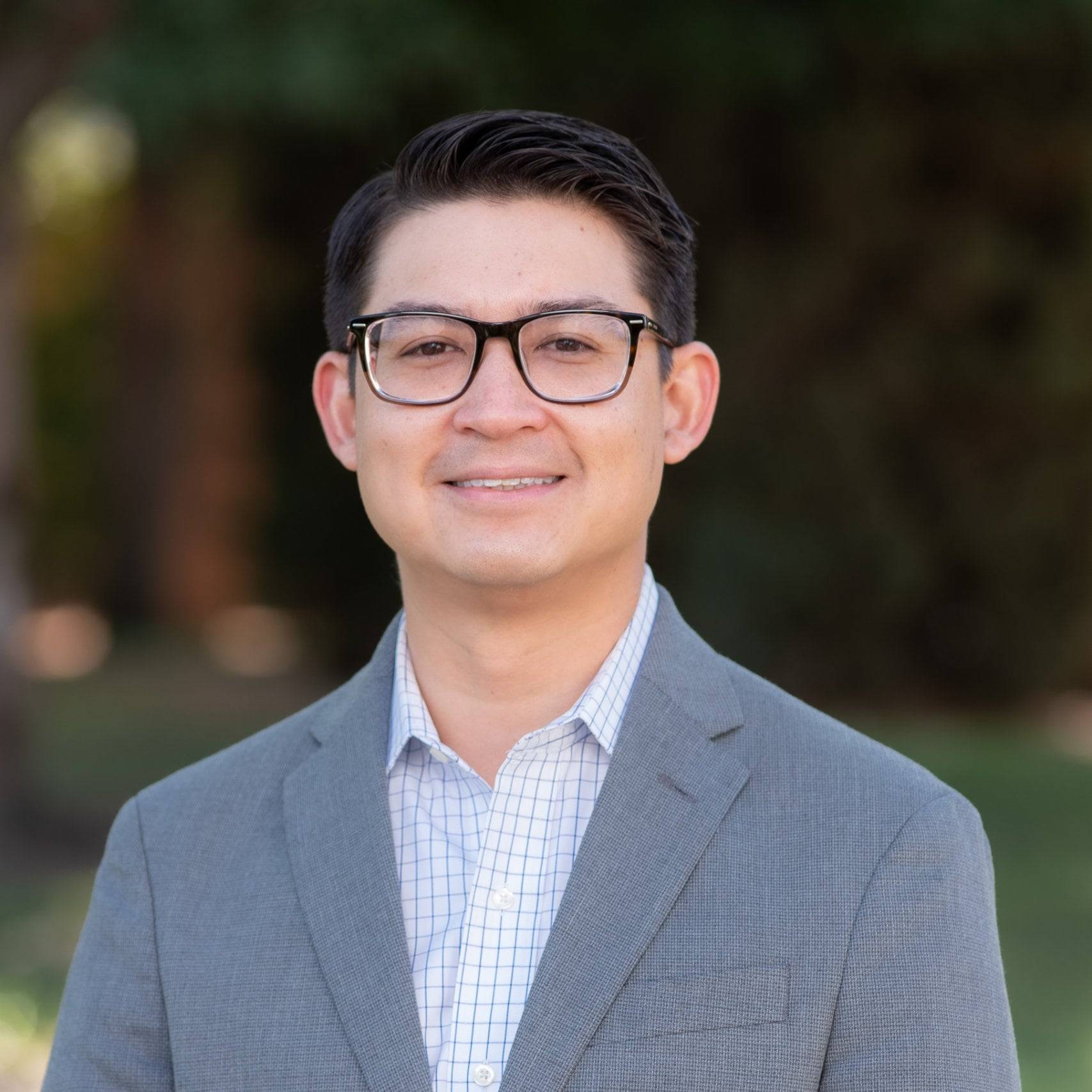 a person wearing glasses and a suit