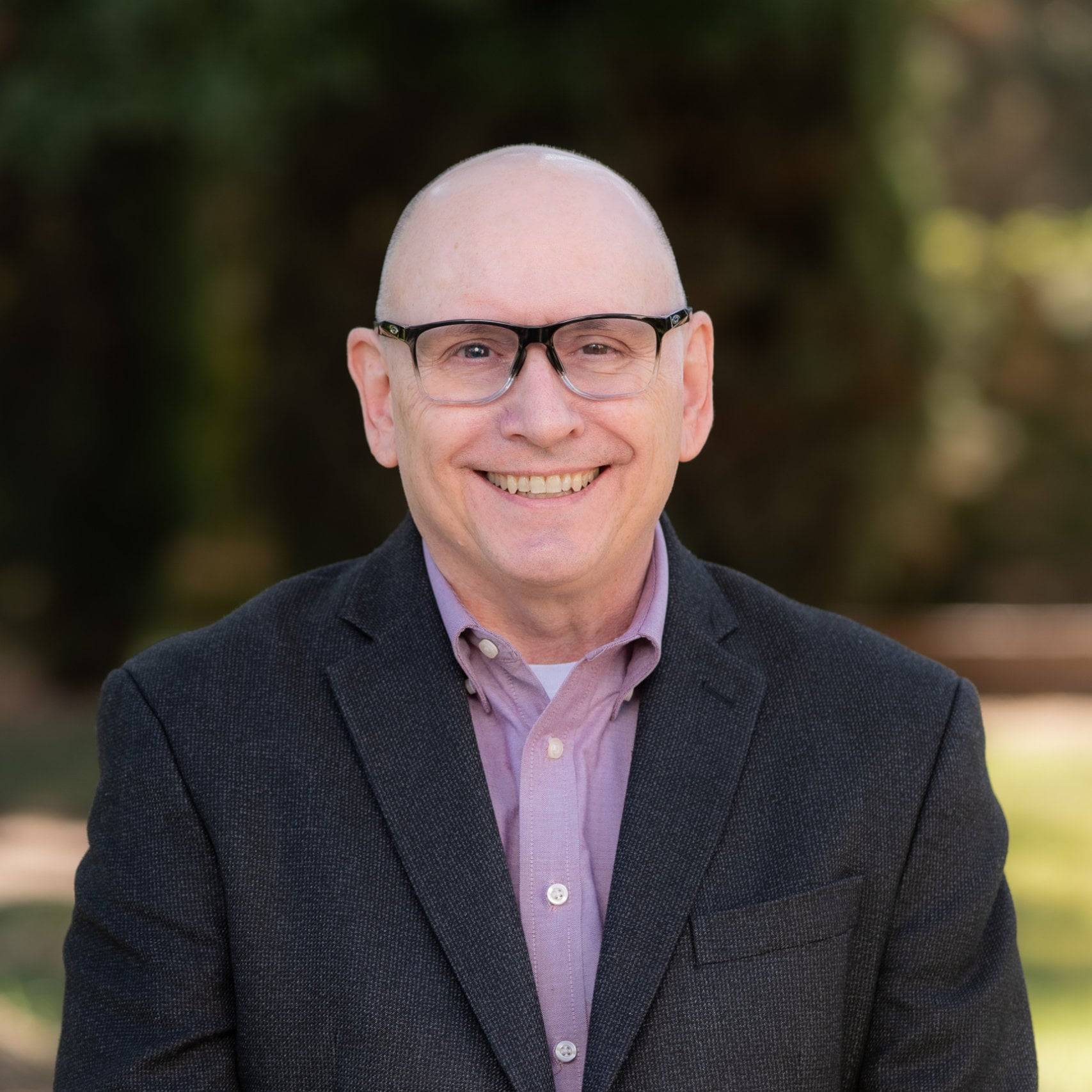 a person wearing glasses and a suit