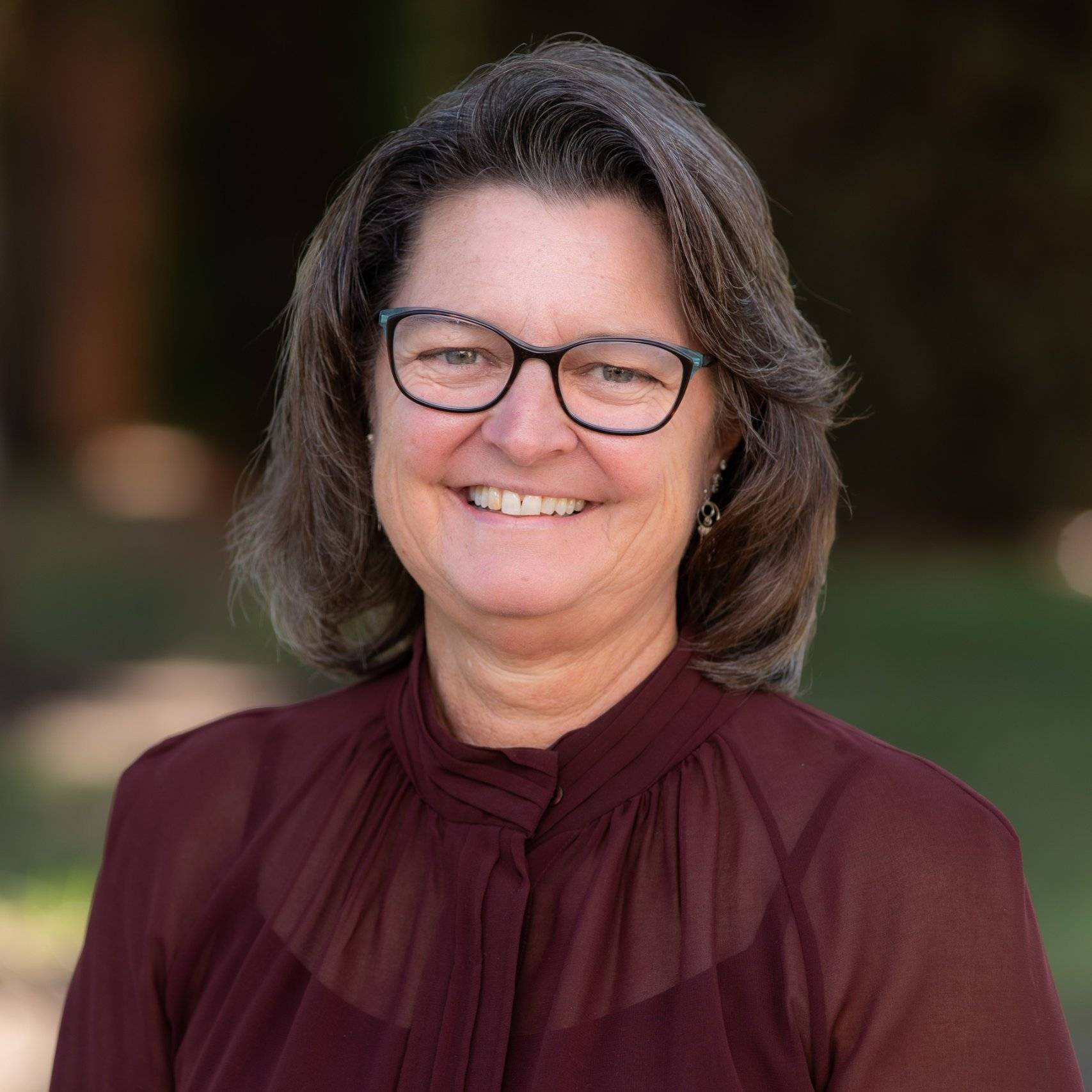 a person wearing glasses smiling