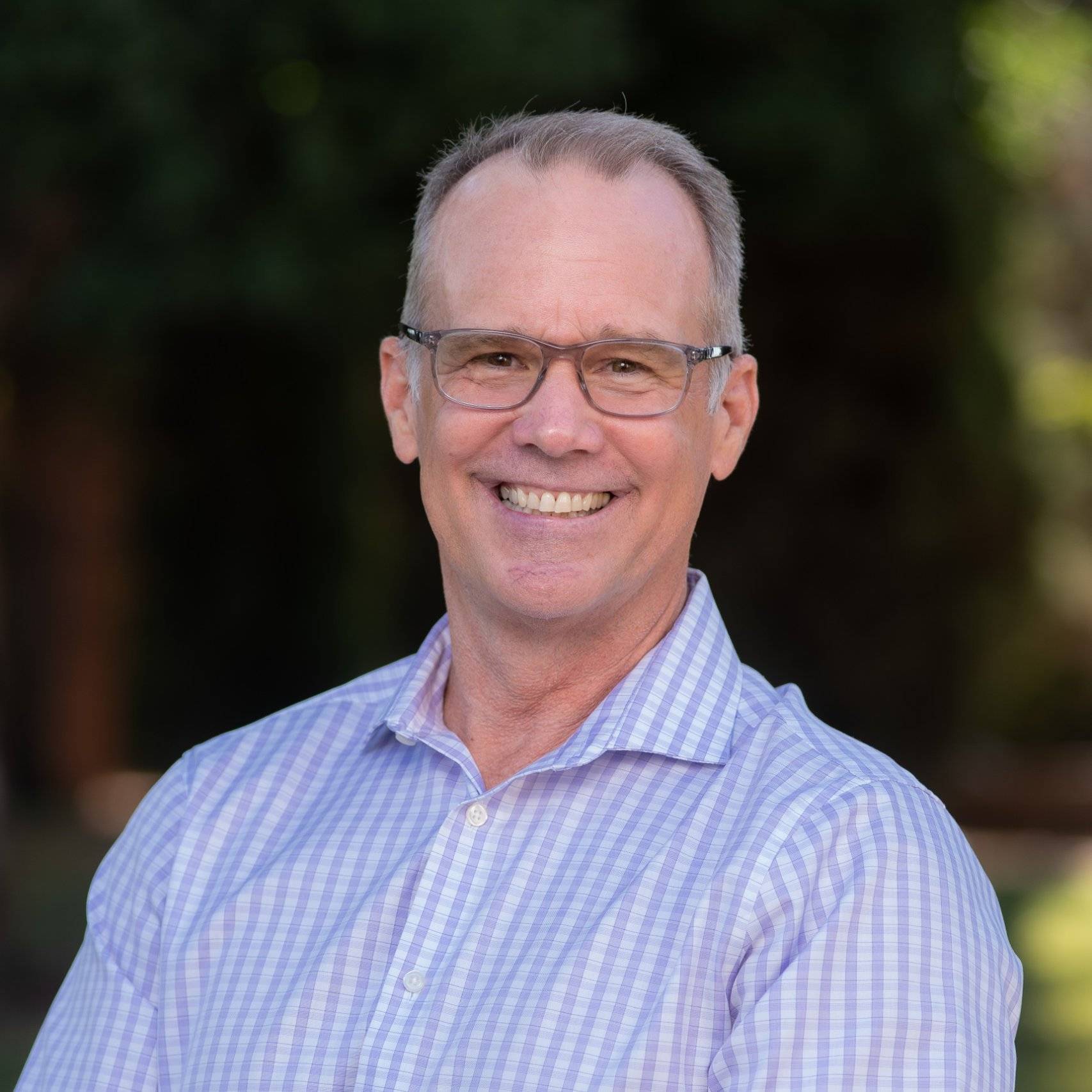 a person wearing glasses smiling