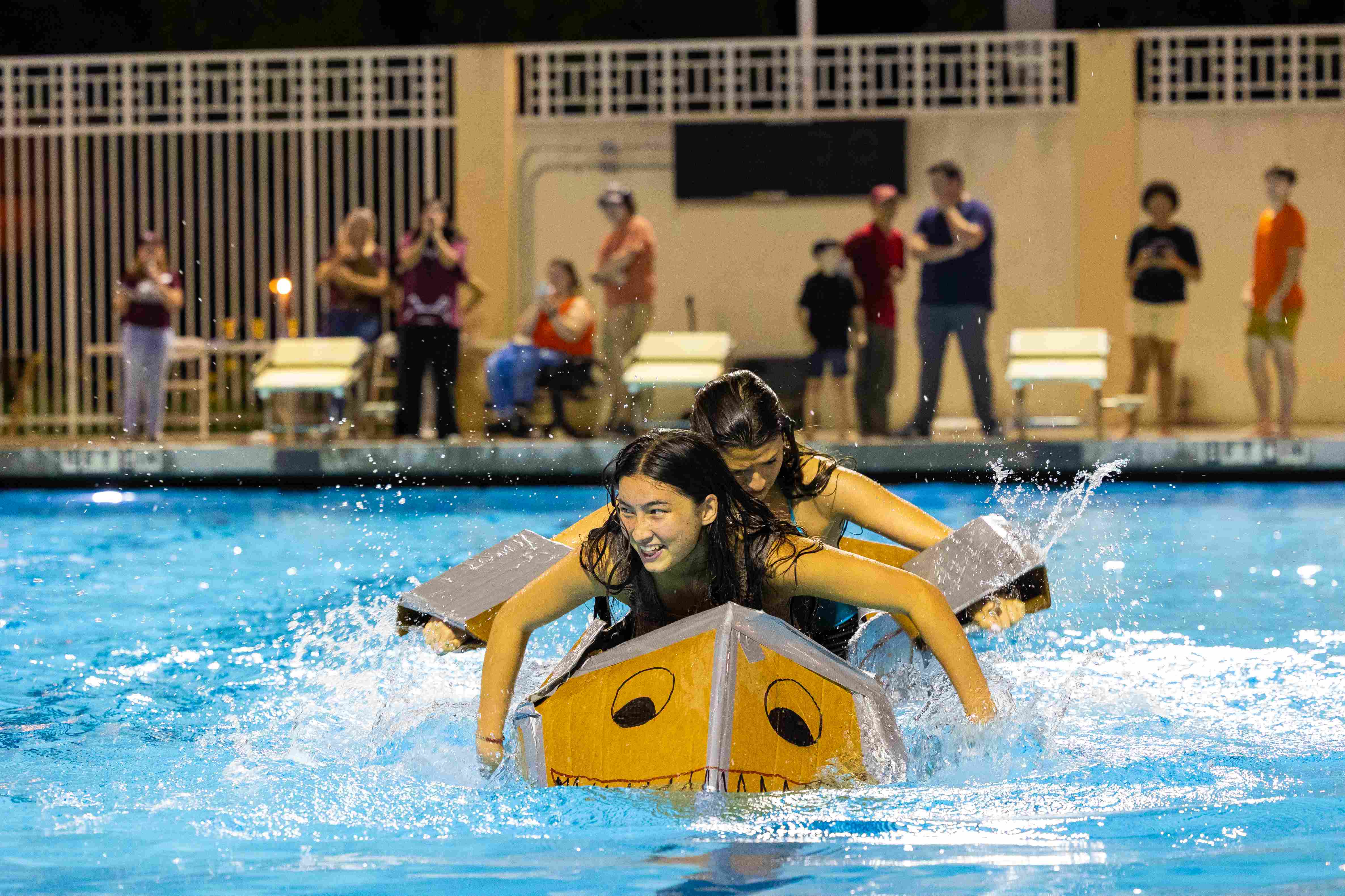 two women in a pool with a boat shaped object