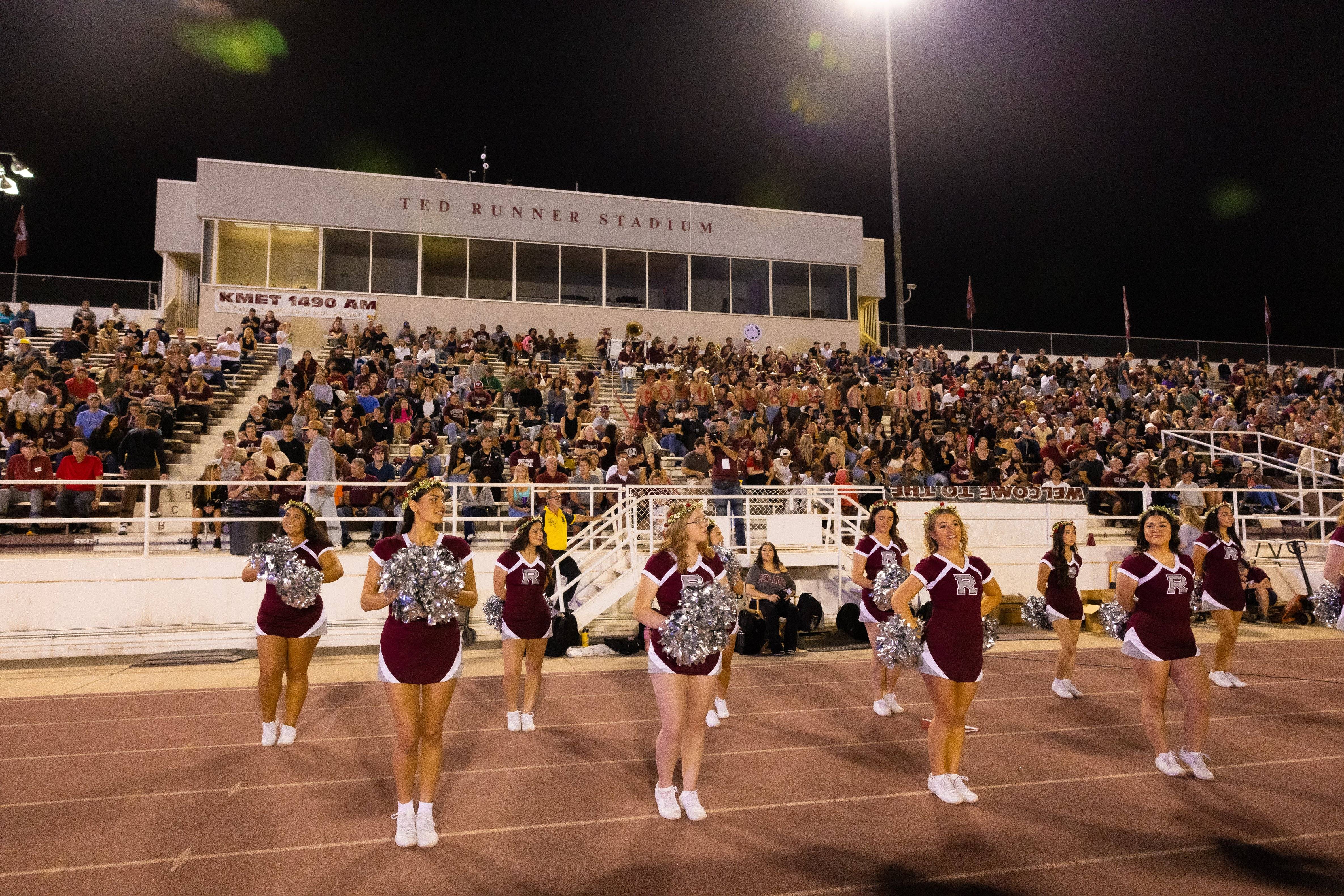 a group of cheerleaders on a football field