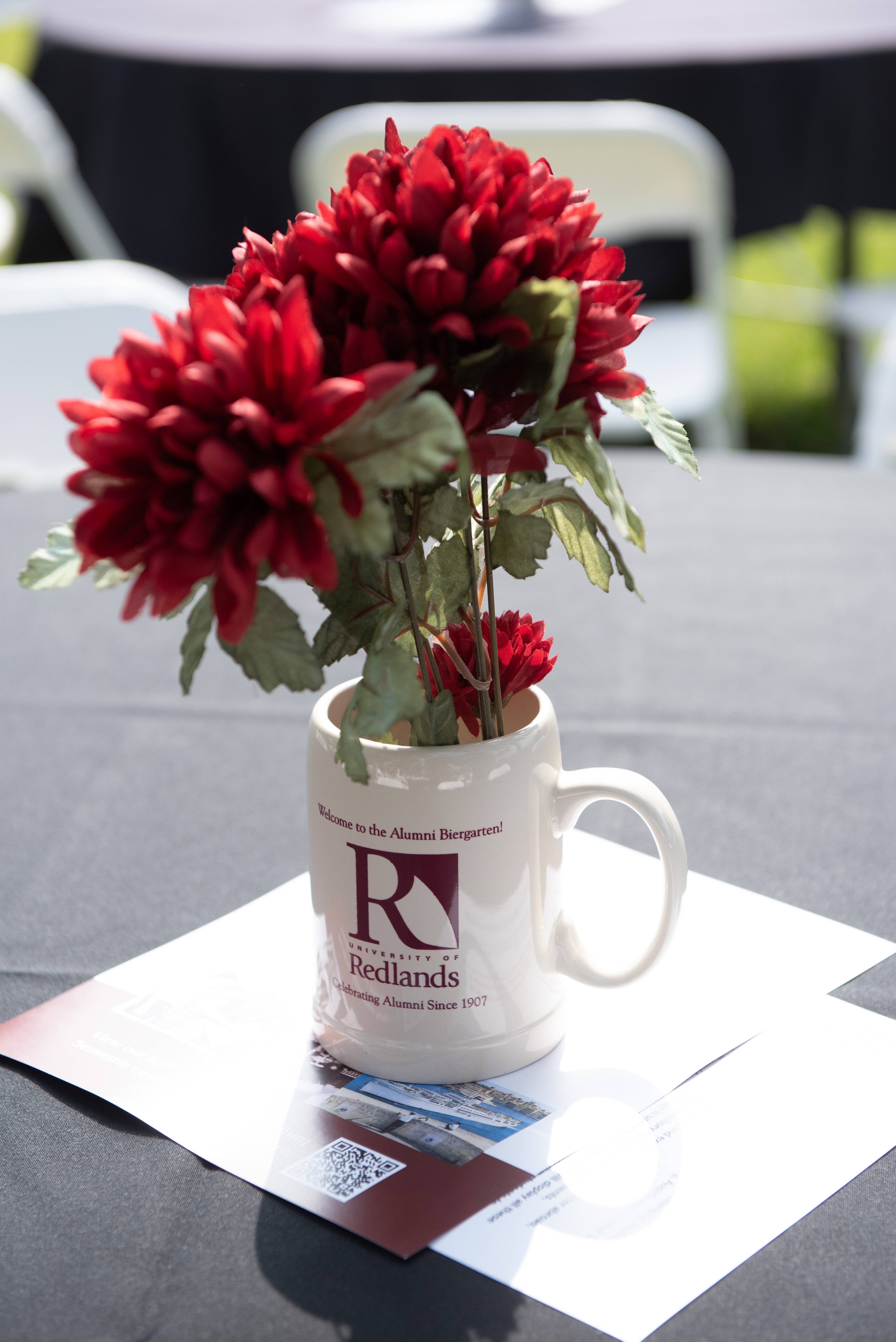 a red flowers in a white mug
