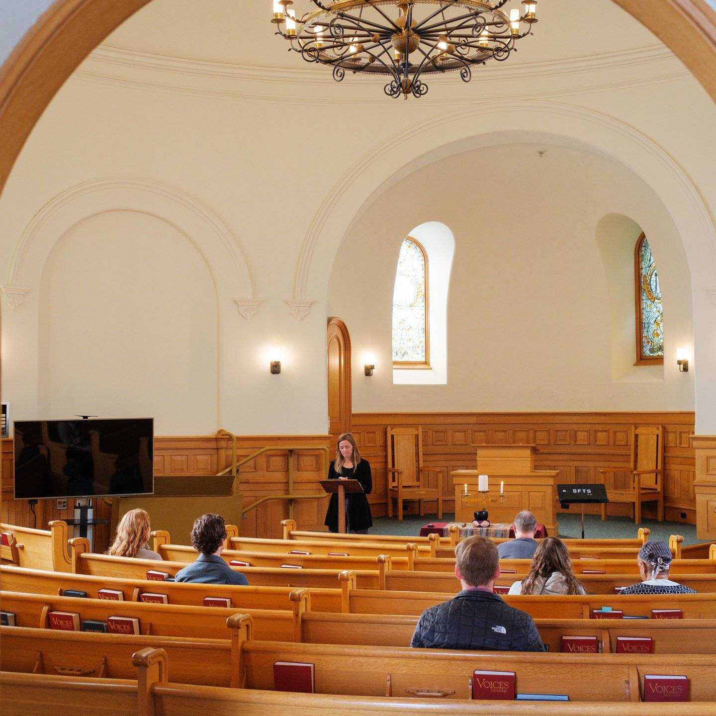 a person standing in a room with a crowd of people