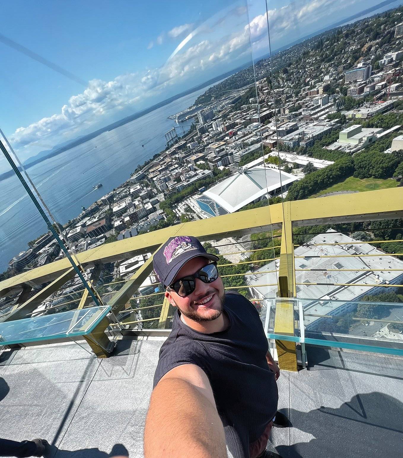 a person taking a selfie on a glass platform above a city