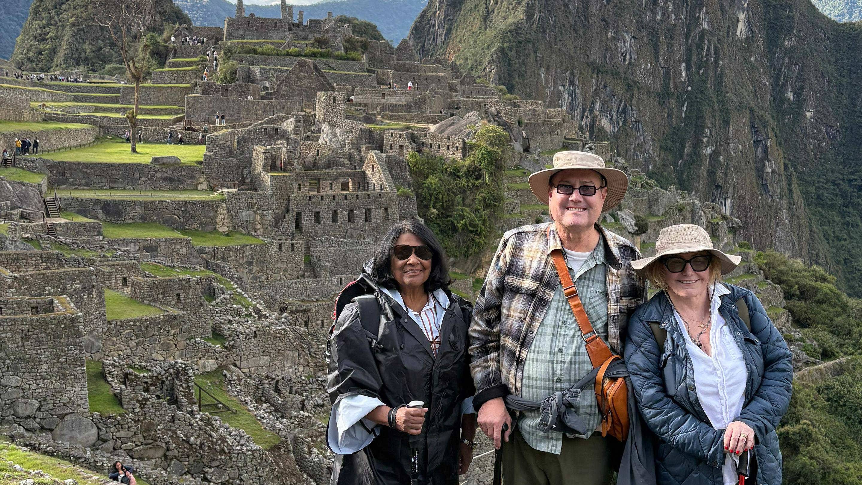 a group of people standing in front of a stone building