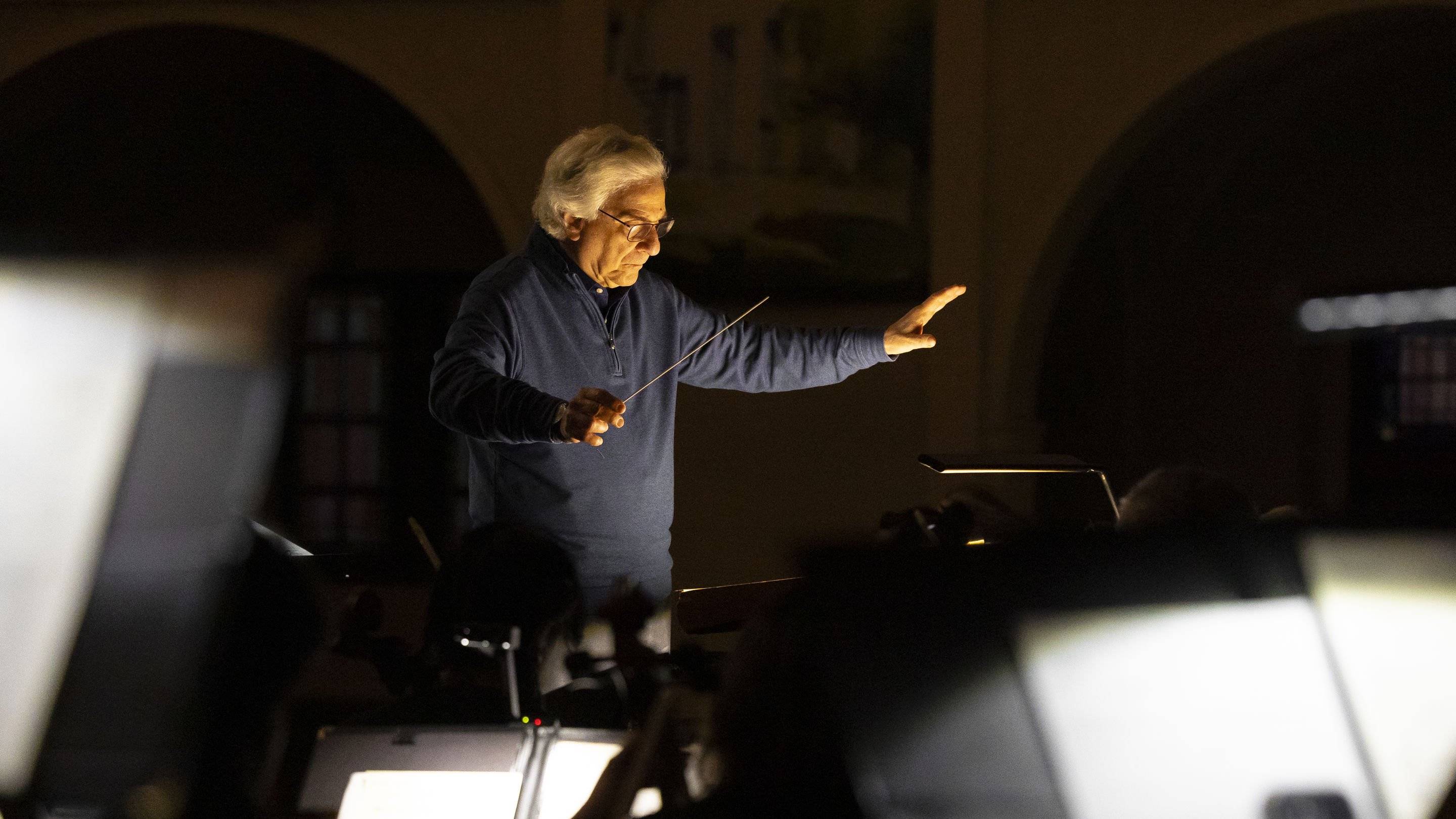 a person holding a stick in front of a piano