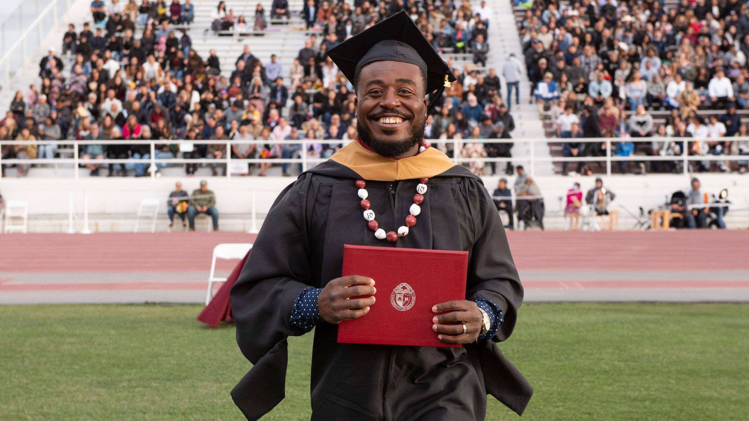 a person in a graduation gown holding a diploma