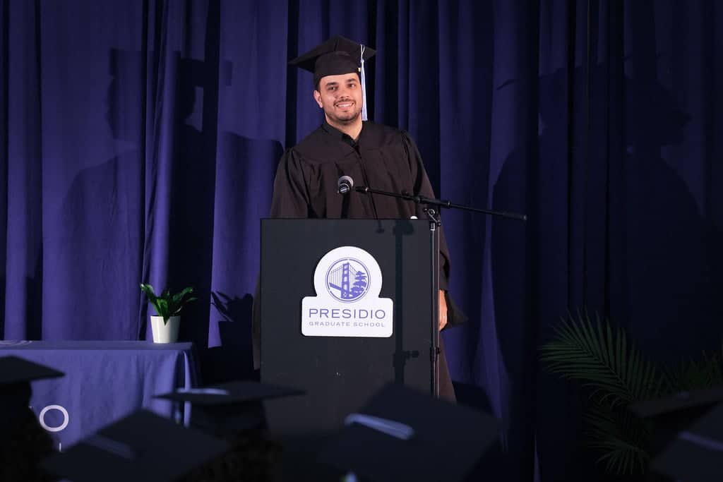 a person in a graduation gown standing at a podium