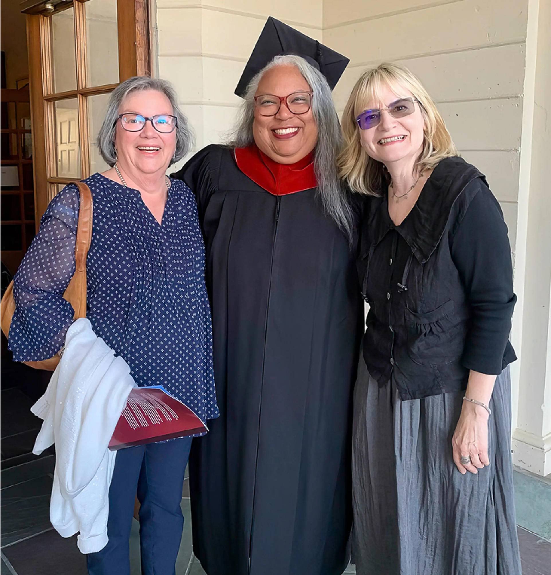 a group of women standing together smiling for a picture