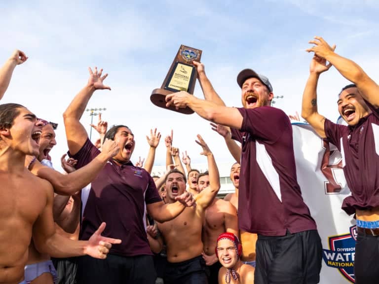 a group of men celebrating with a trophy