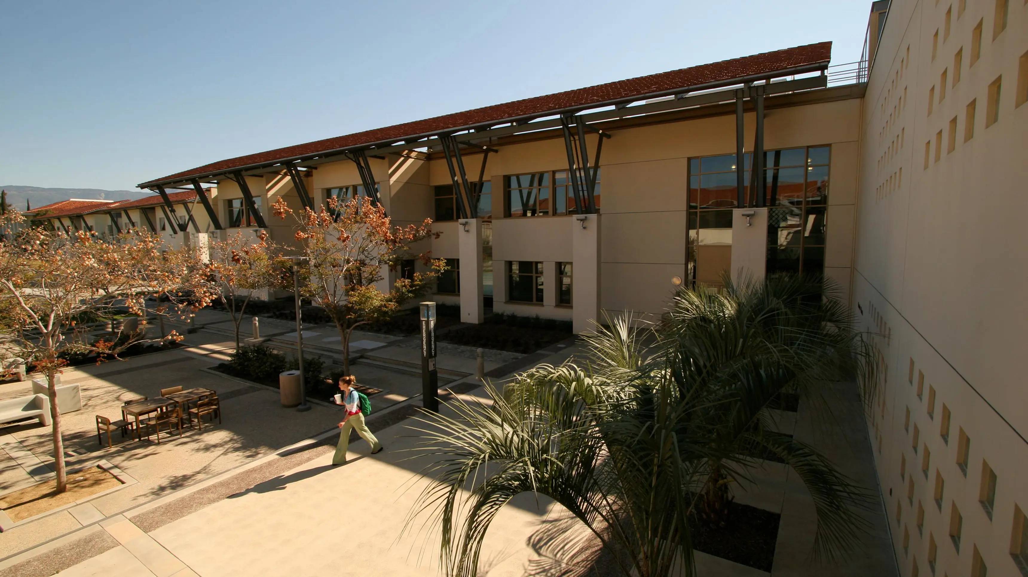a person walking down a sidewalk in front of a building