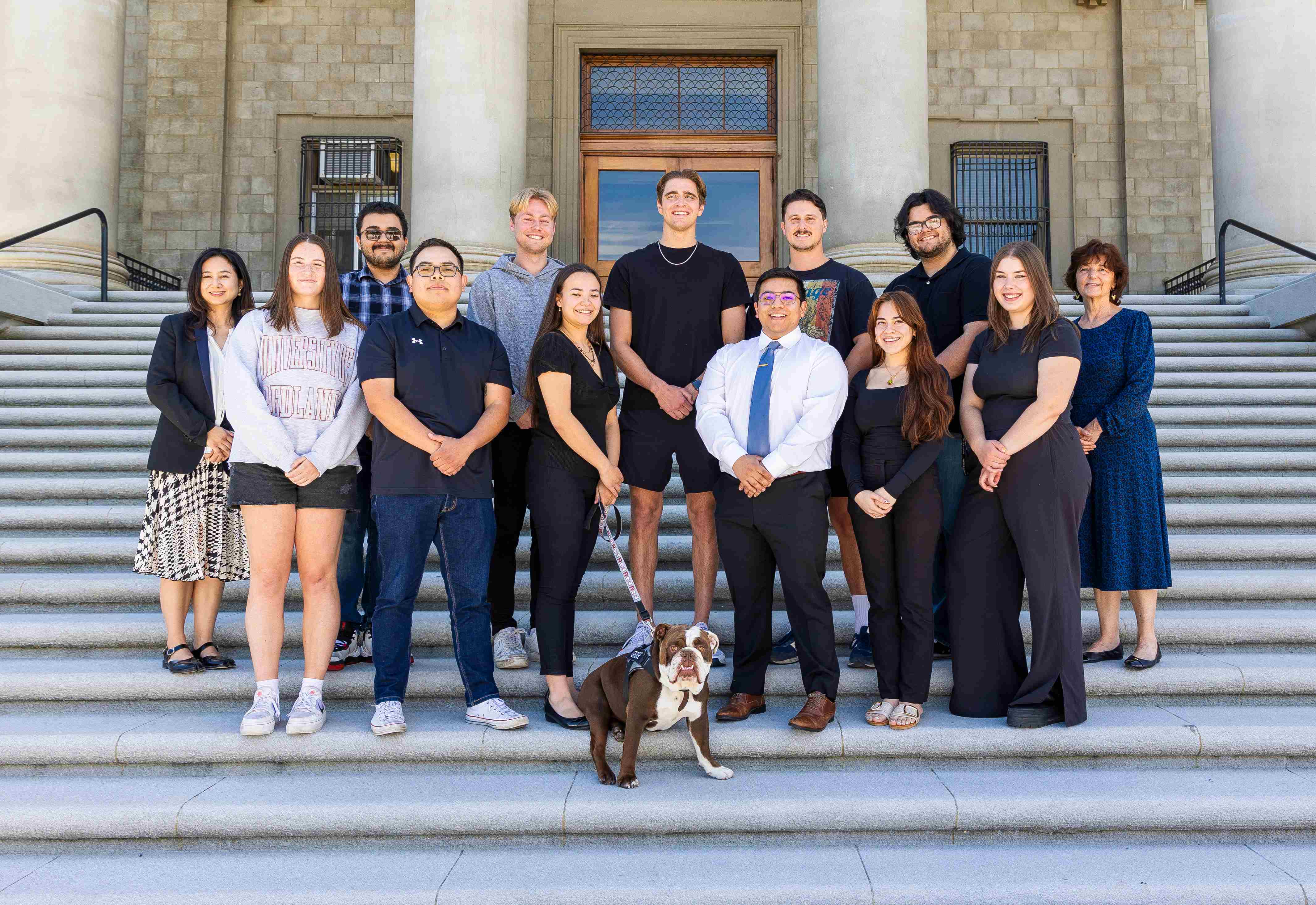 a group of people standing on steps with a dog