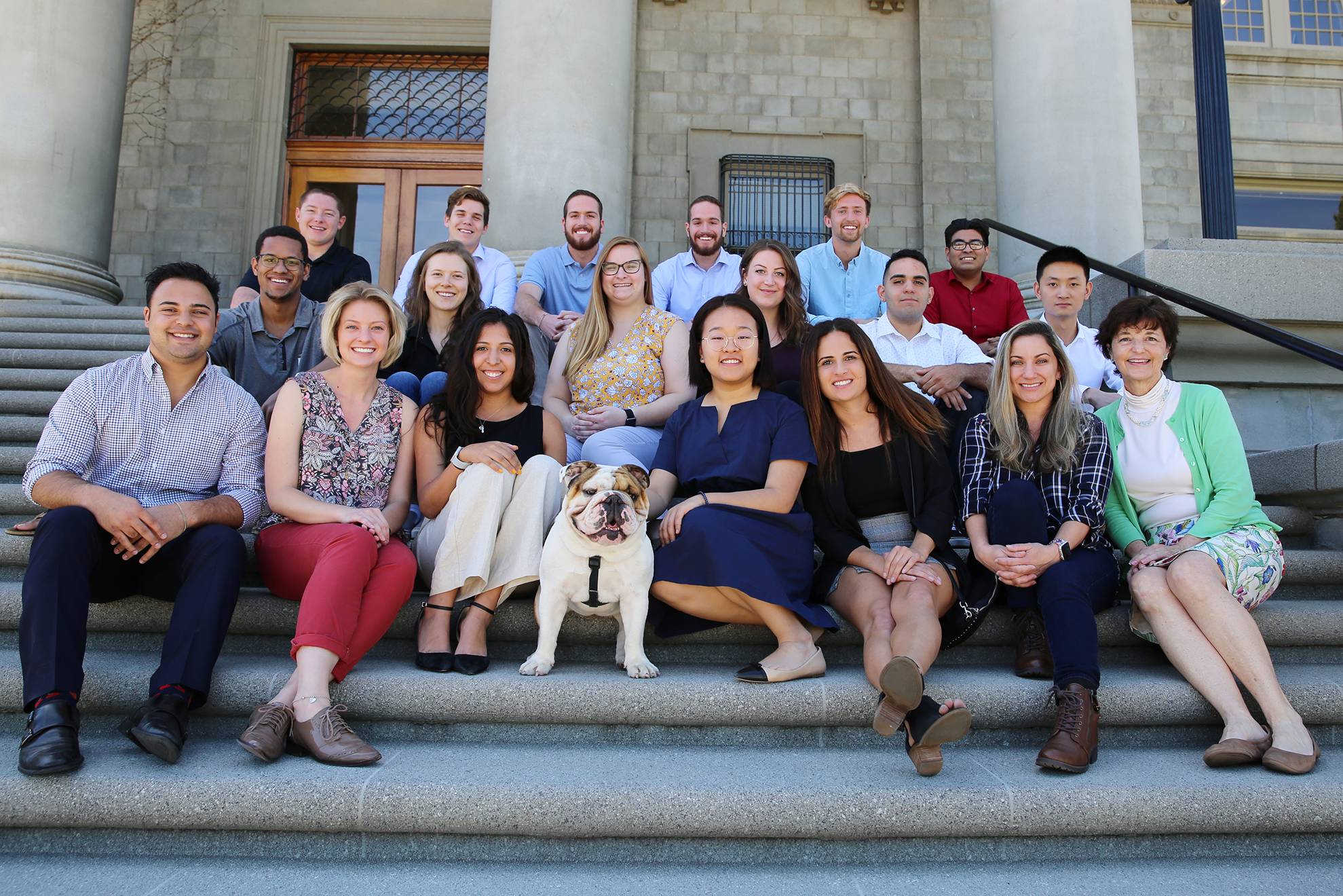 a group of people sitting on steps with a dog