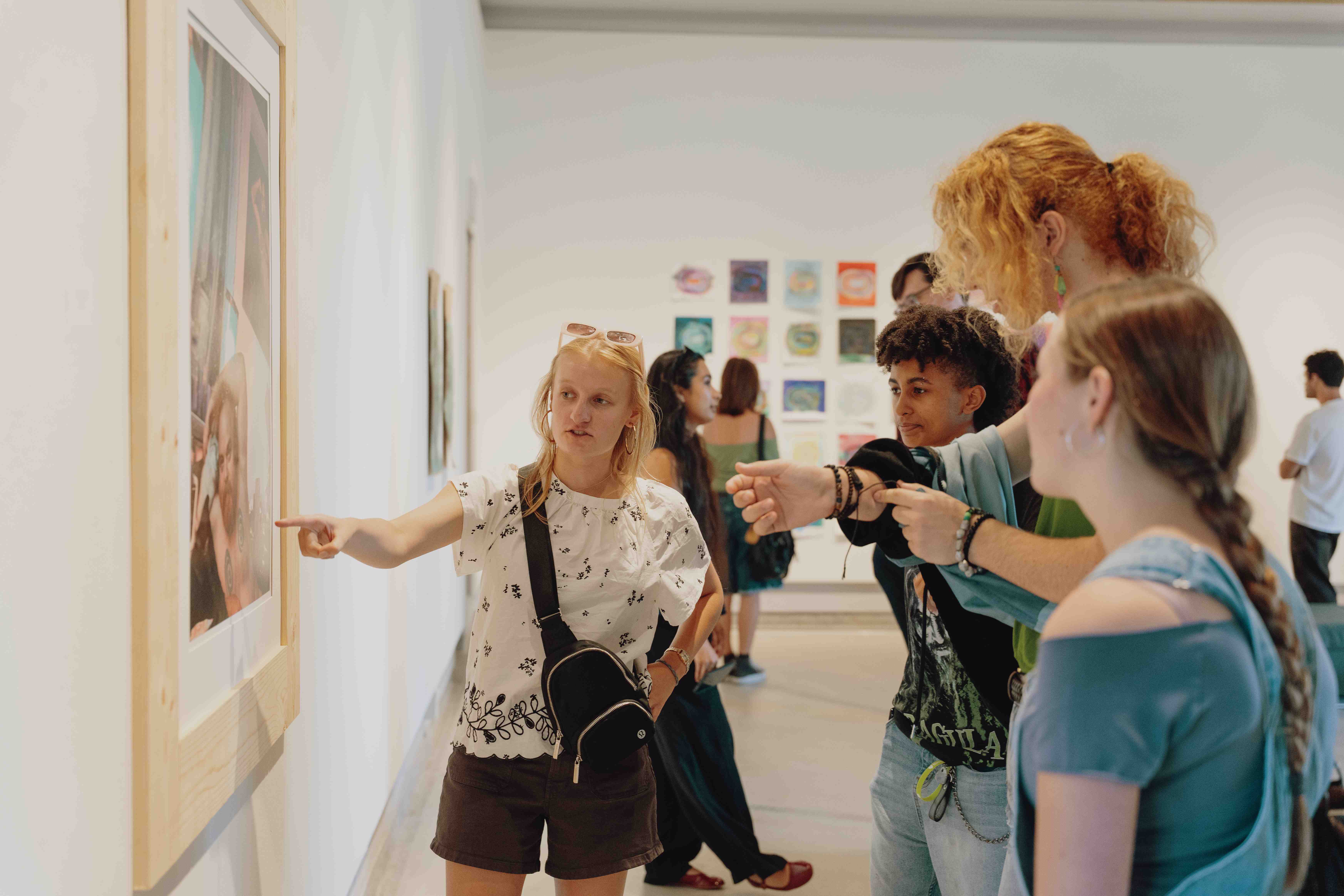 a group of people looking at a painting