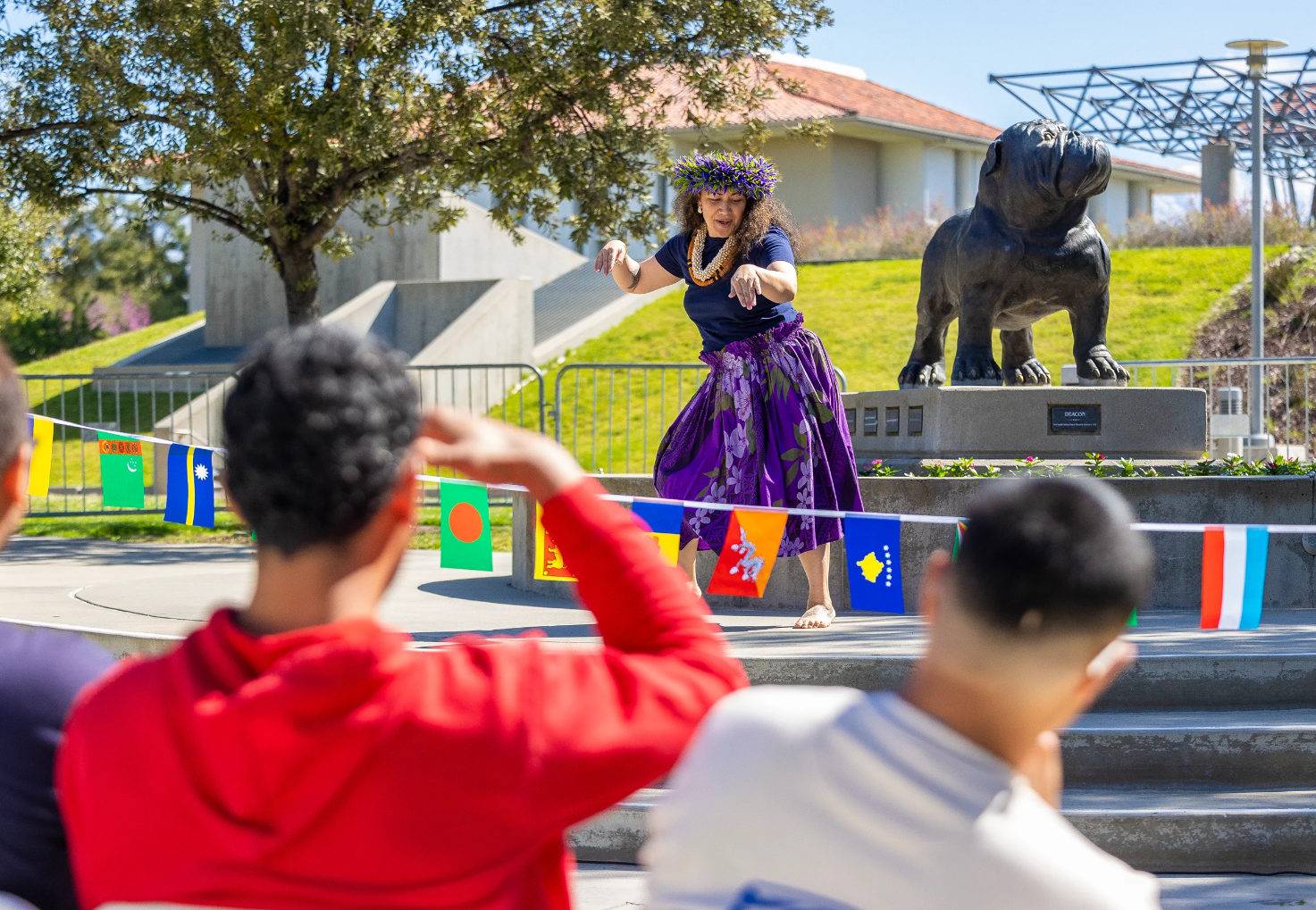 a person dancing in a purple dress with a flower crown and a person in a red shirt