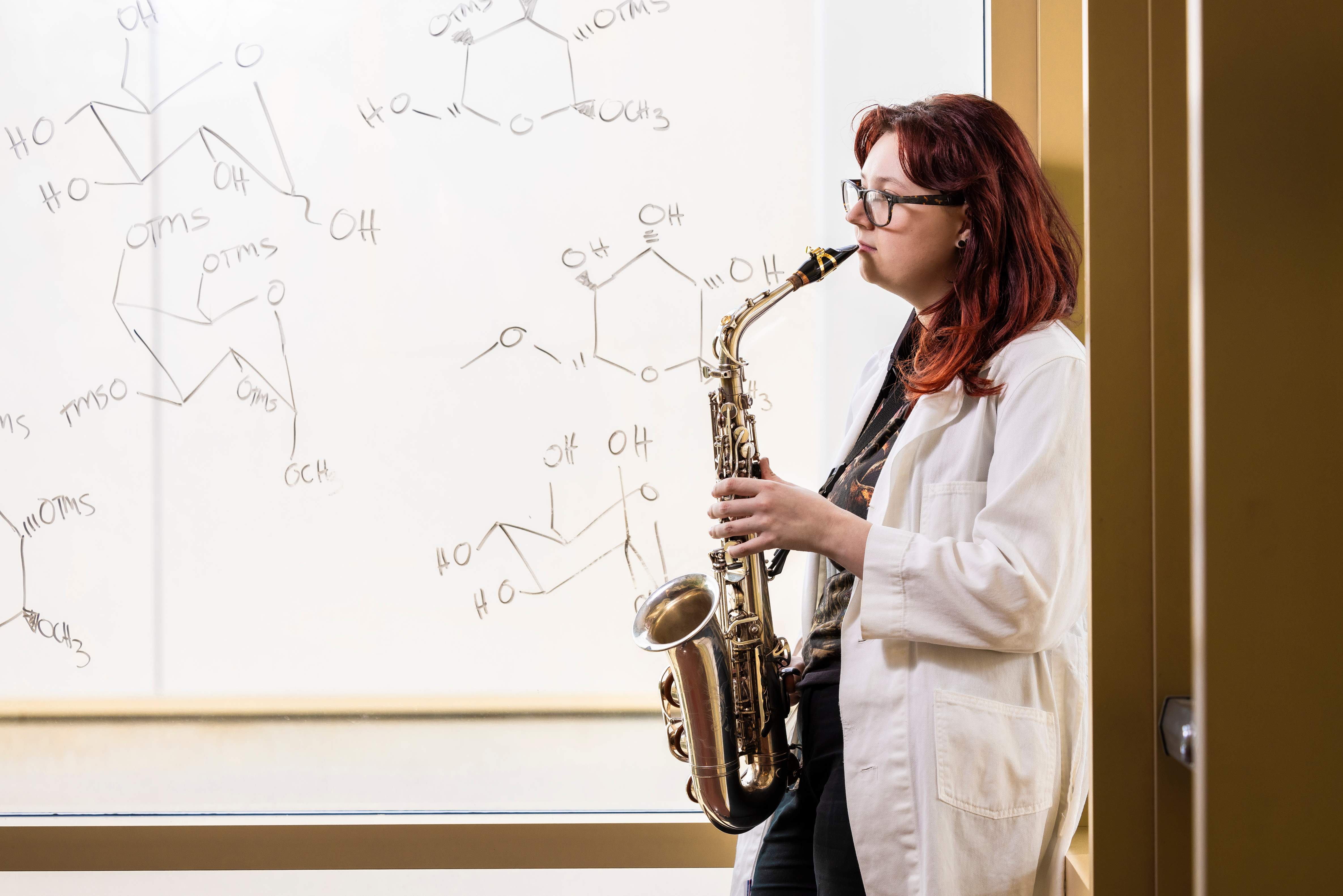 a person in a white coat playing a saxophone