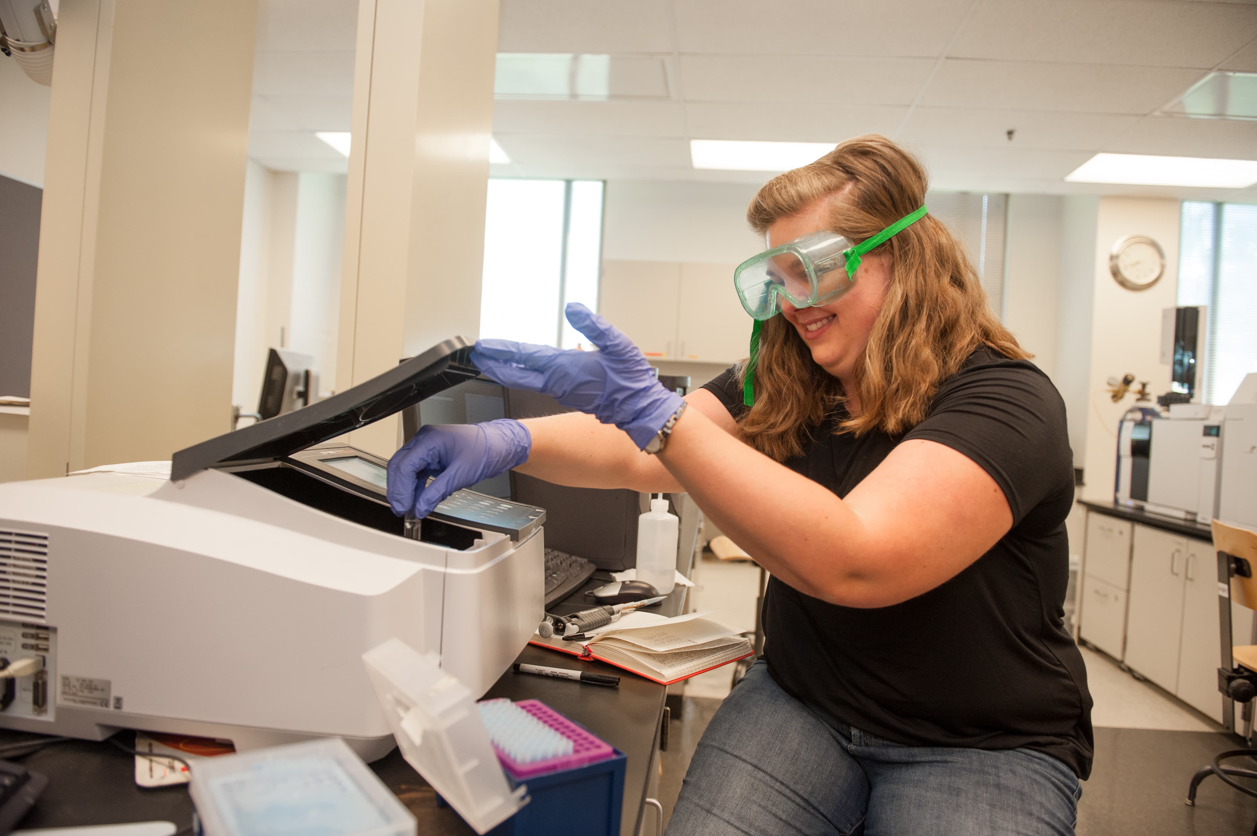 a person wearing safety goggles and gloves