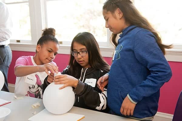 a group of childs working on a balloon