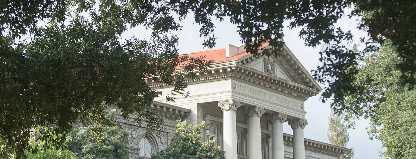 a building with columns and a red roof