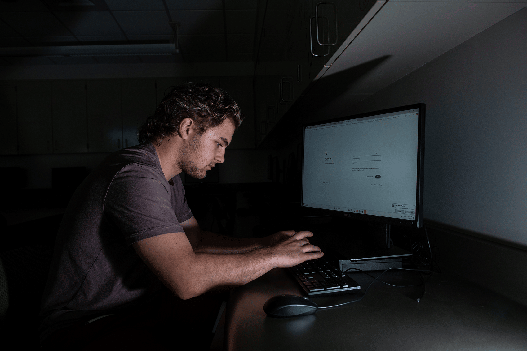 a person sitting at a desk working on a computer