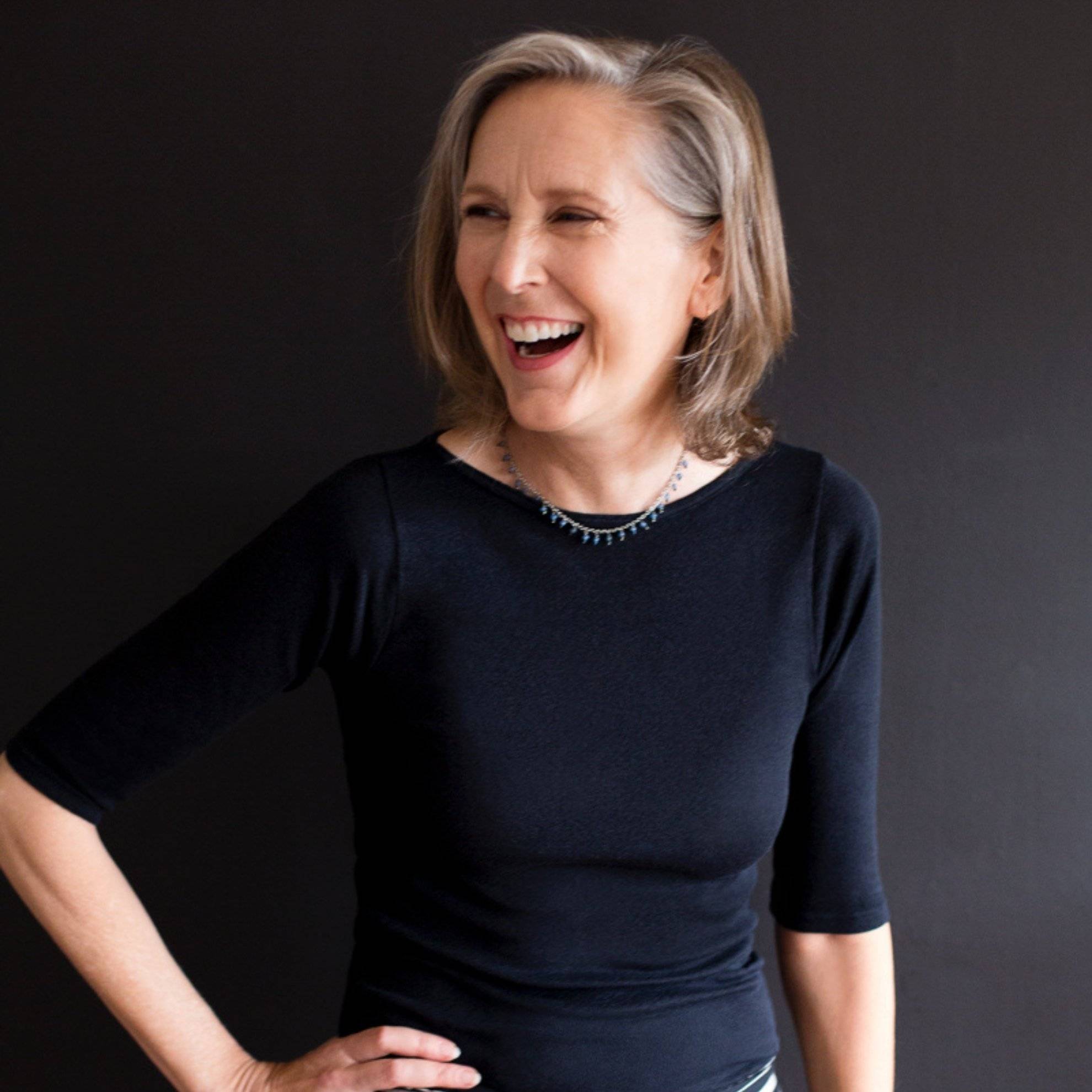 a person laughing with her hand on her hip