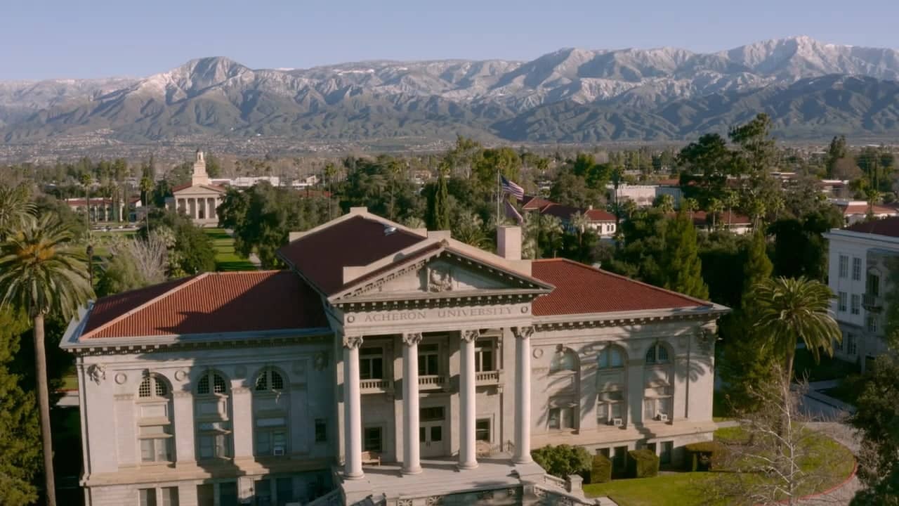 a building with a large building and mountains in the background