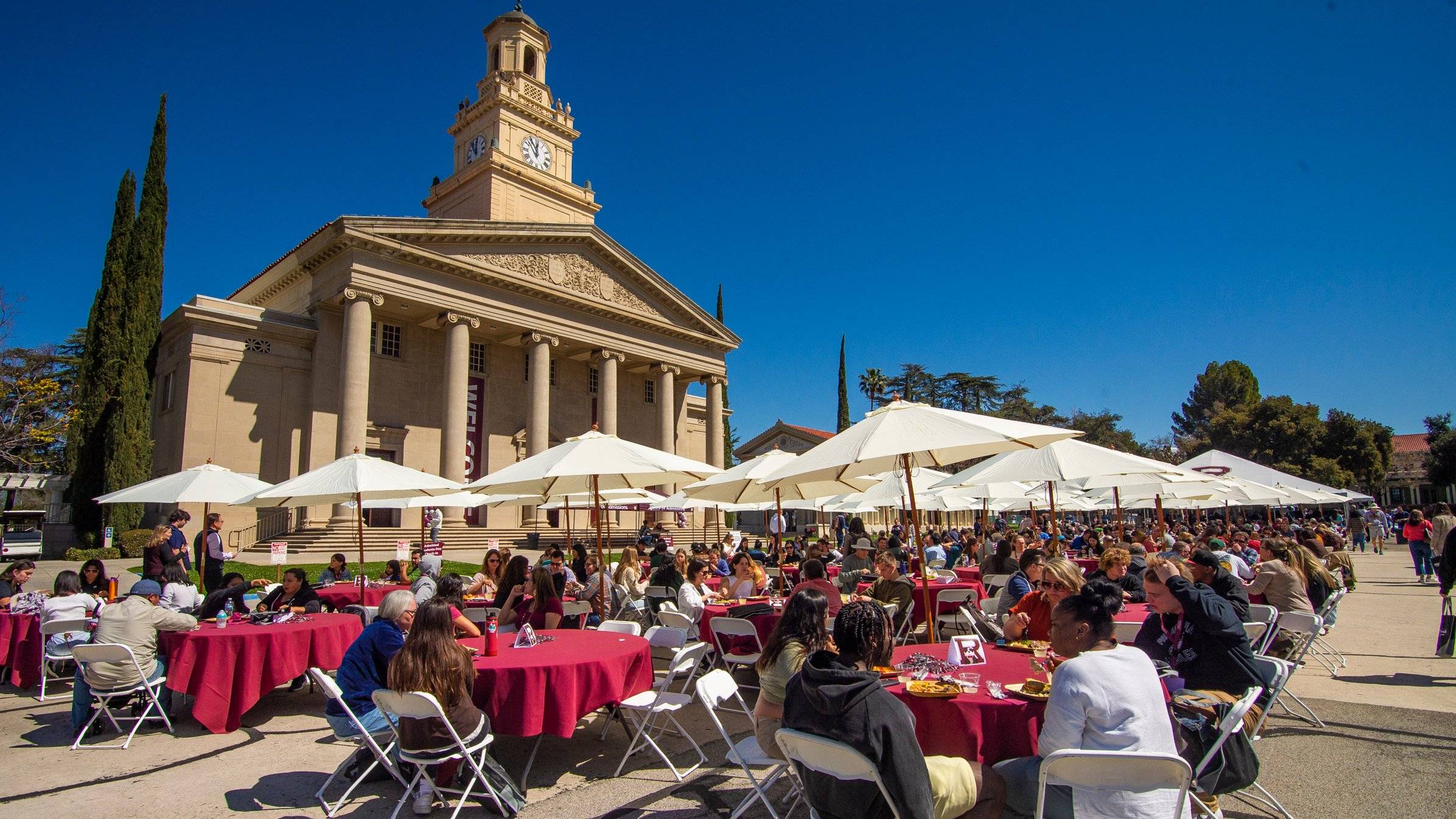 a group of people sitting at tables outside a building
