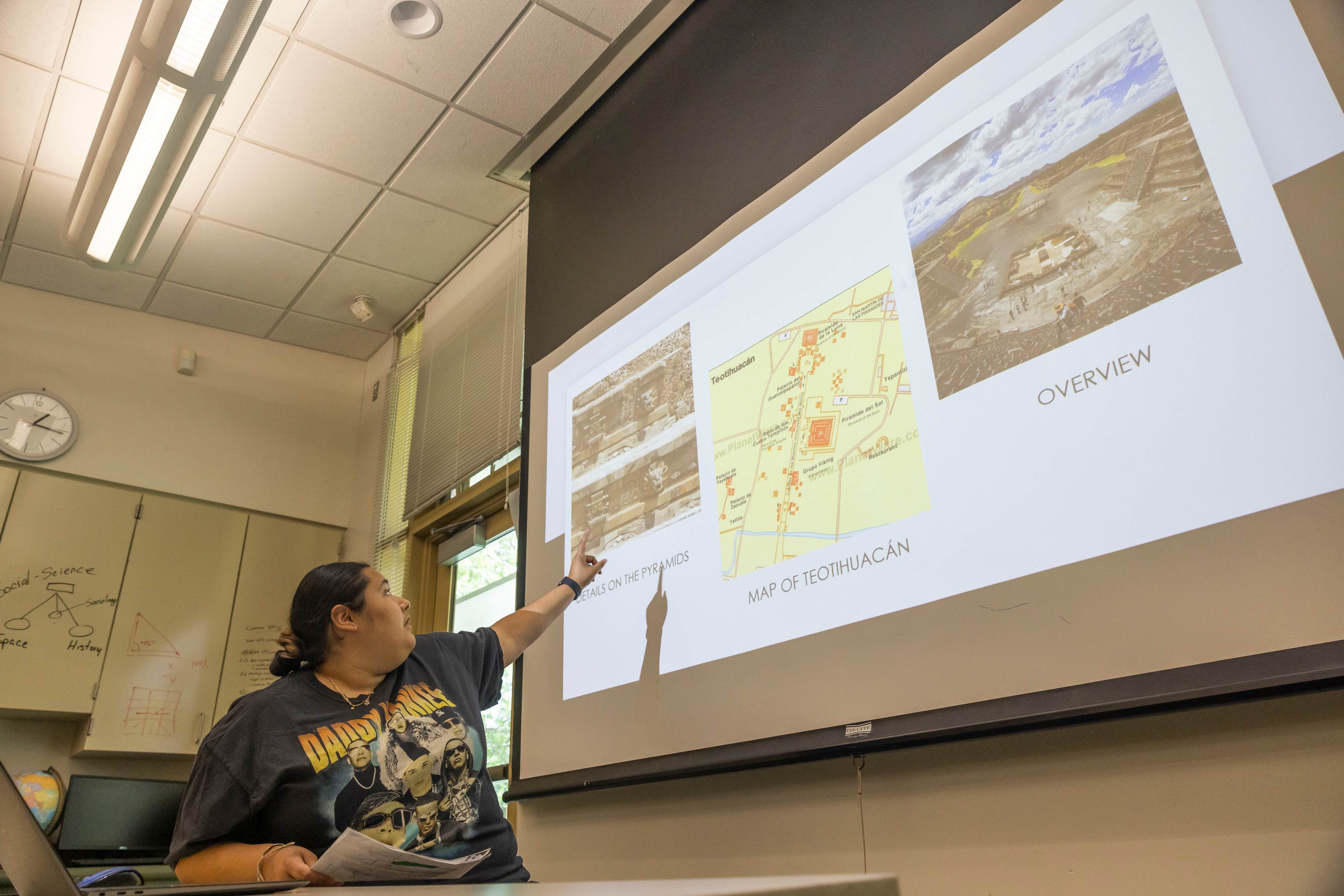 a person pointing at a projector screen