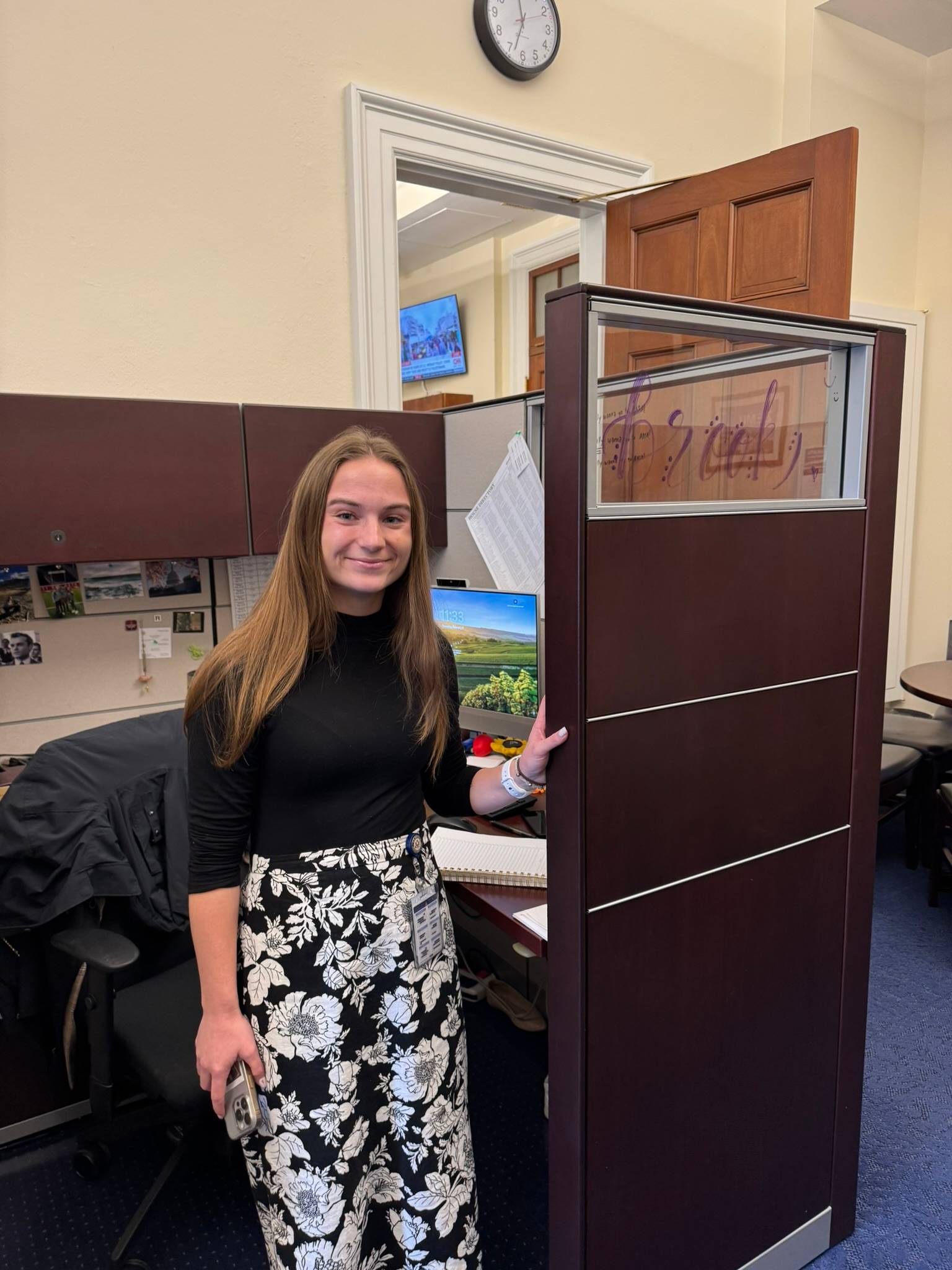 a person standing next to a tall wooden cubicle