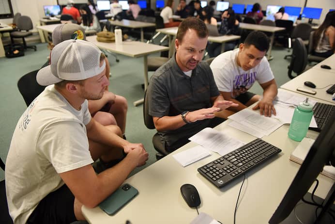 a group of men sitting at a desk with papers