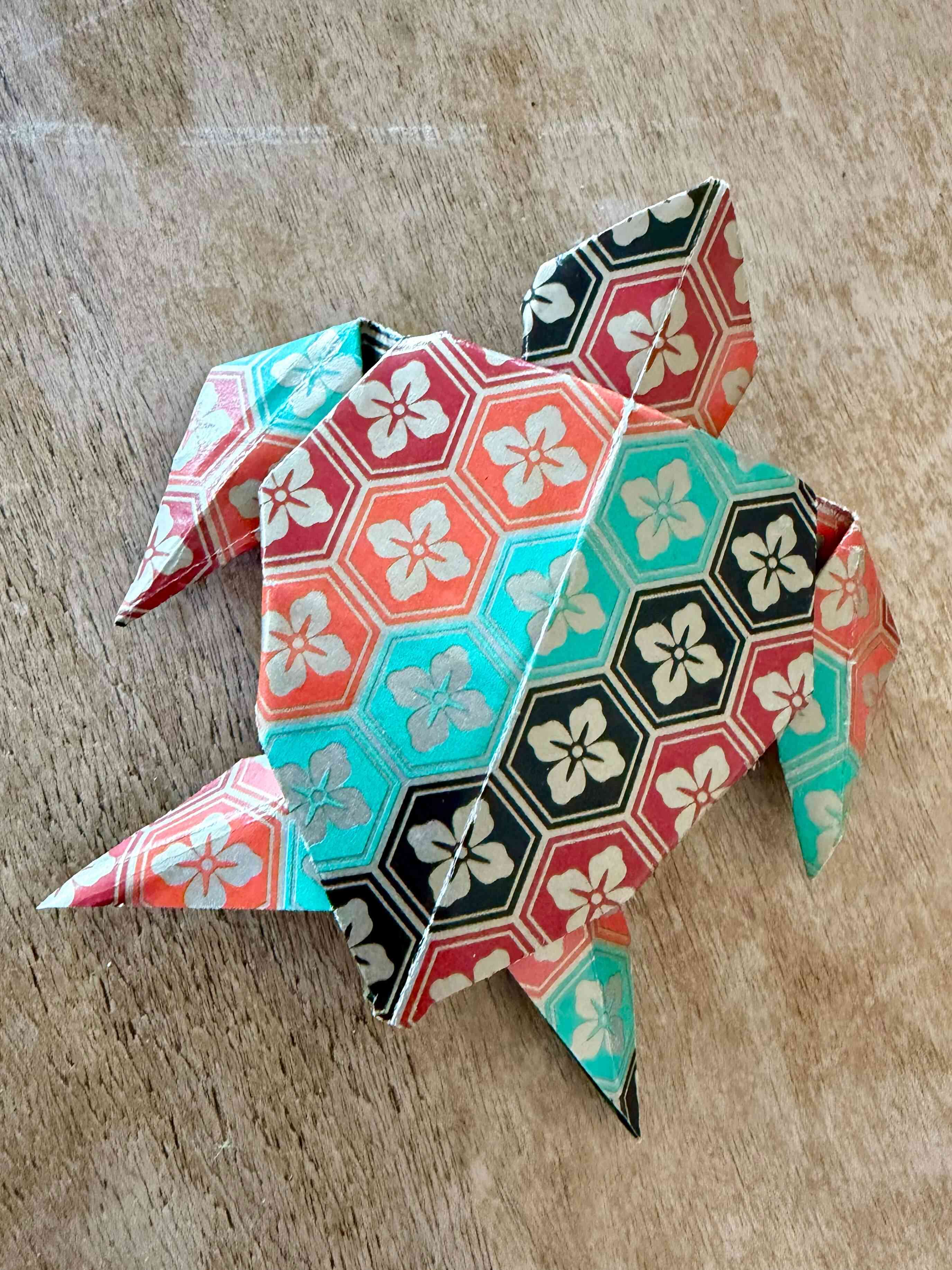 a paper turtle on a wood surface