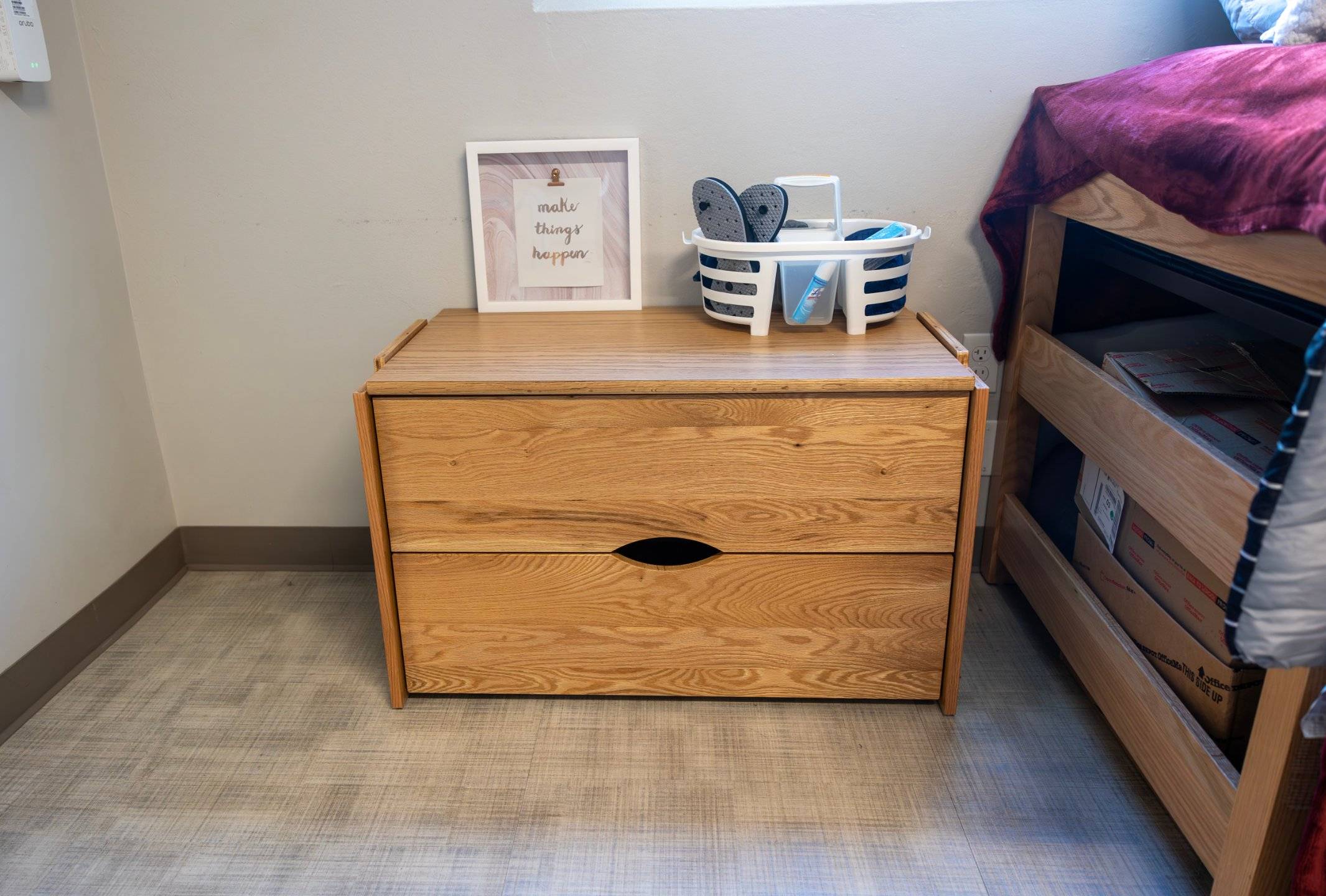 a wooden chest with a picture frame and a basket on top