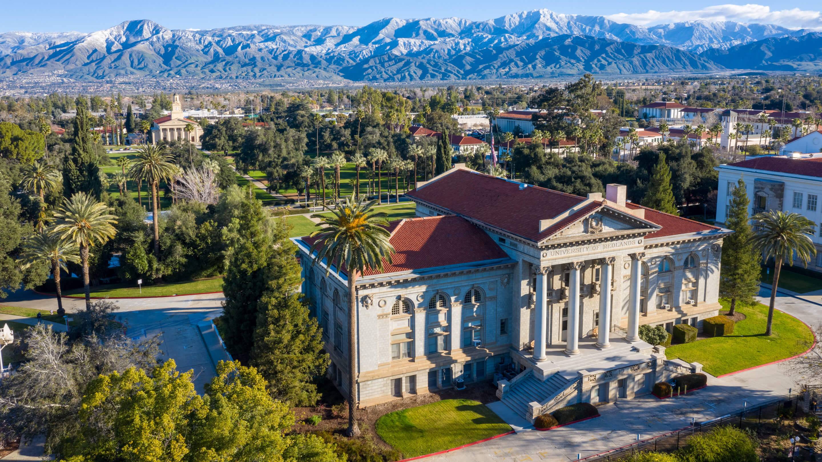 a large building with columns and a lawn and trees