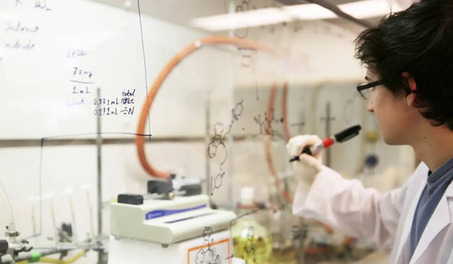 a person writing on a glass wall