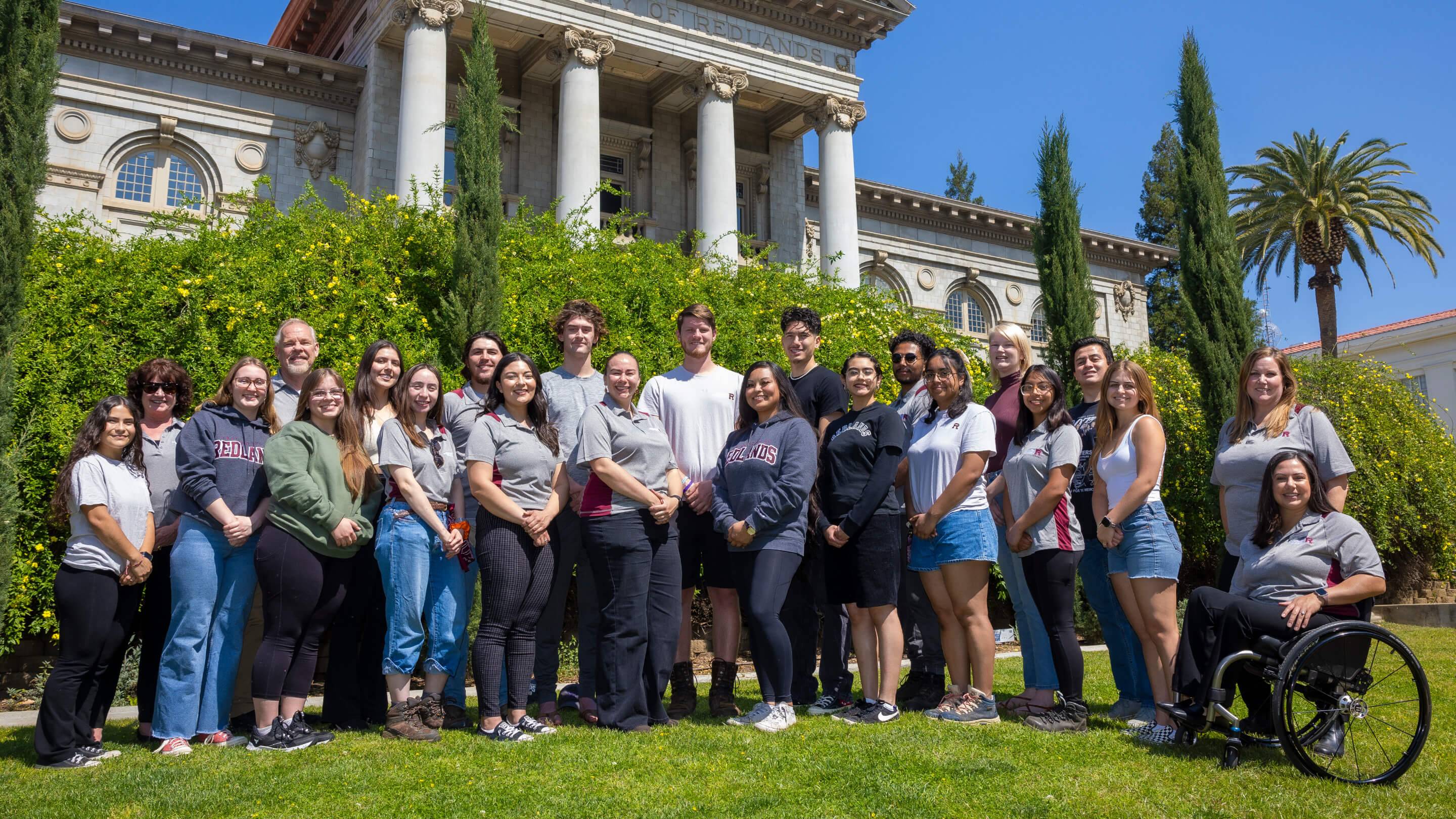 a group of people posing for a photo in front of a building