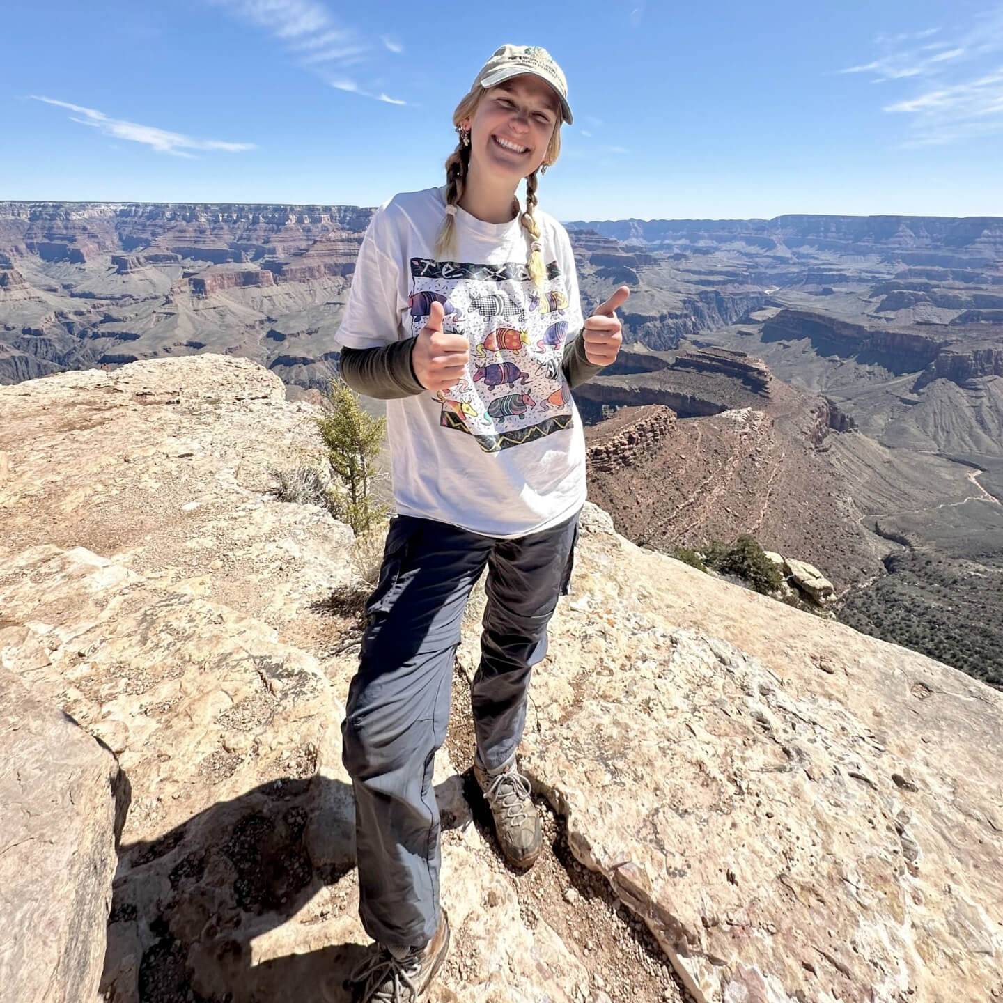 a person standing on a rock with two thumbs up