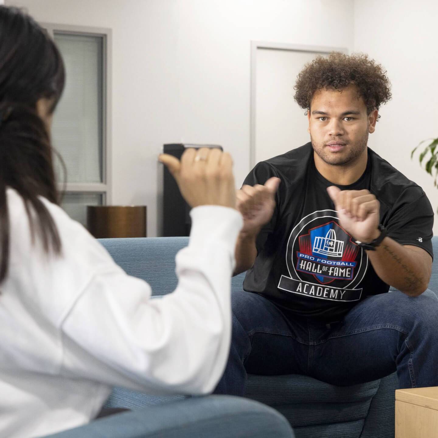 a person sitting on a couch and talking to a person