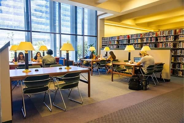 people sitting at tables in a library