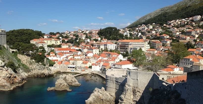 a city with red roofs and a body of water